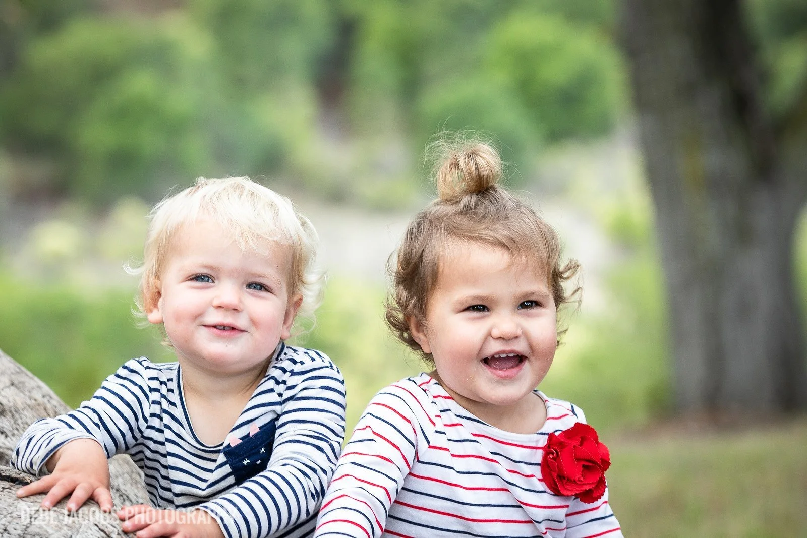 Two smiling toddlers in striped shirts posing outdoors at Filoli.