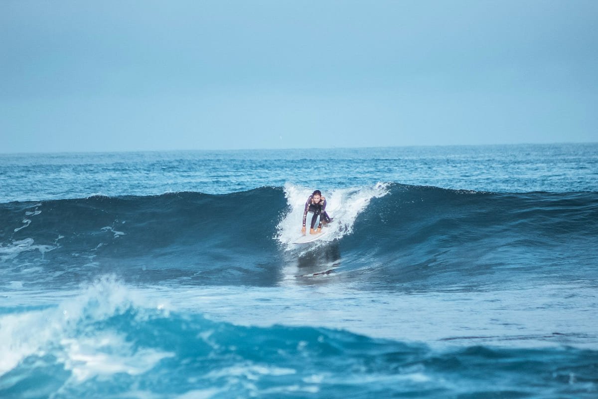 A person surfing on a wave in Tortuga Bay Galapagos