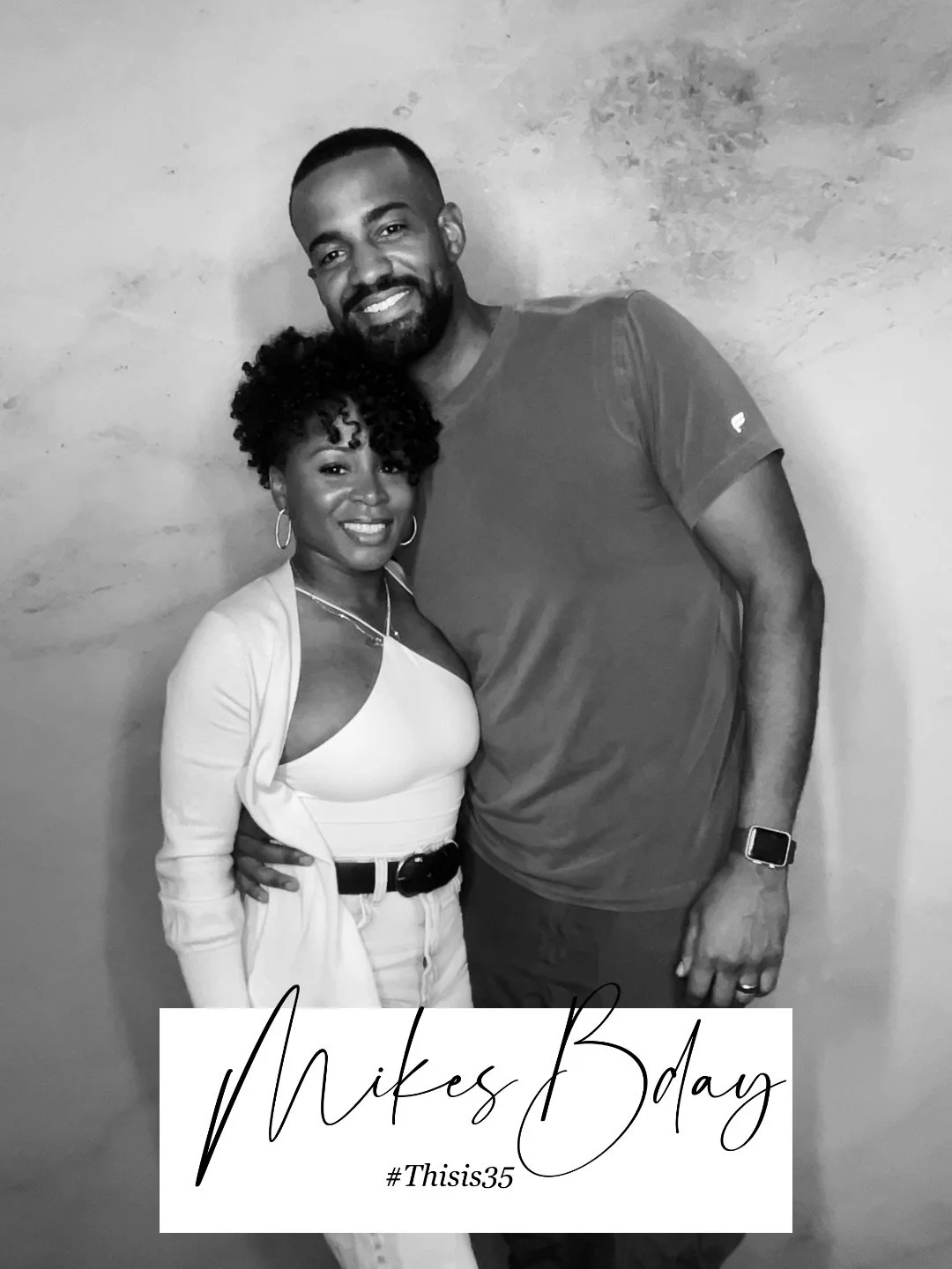 A black and white photo of a smiling couple posing together, with the man wearing a casual t-shirt and the woman in a light top with a sweater. At the bottom, there is text reading “Mike's Bday #Thisis35.”