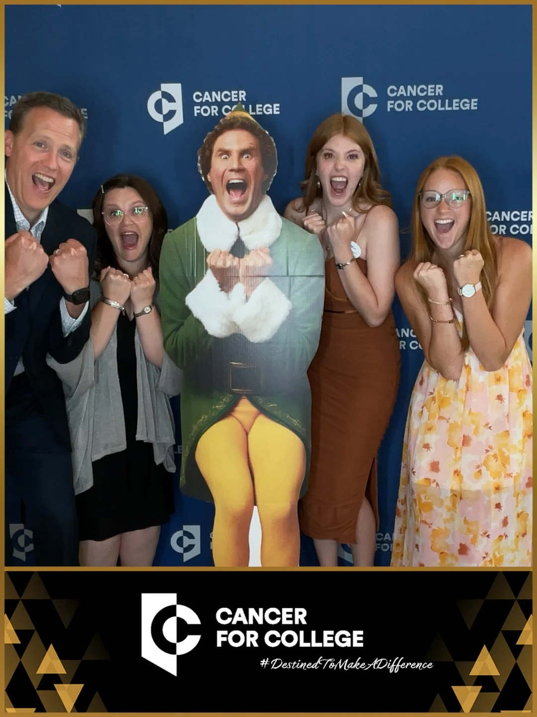 Group of four guests posing excitedly with a cardboard cutout of buddy the elf at the annual Cancer for College fundraser at the Nascar Hall of Fame Charlotte , Nc.