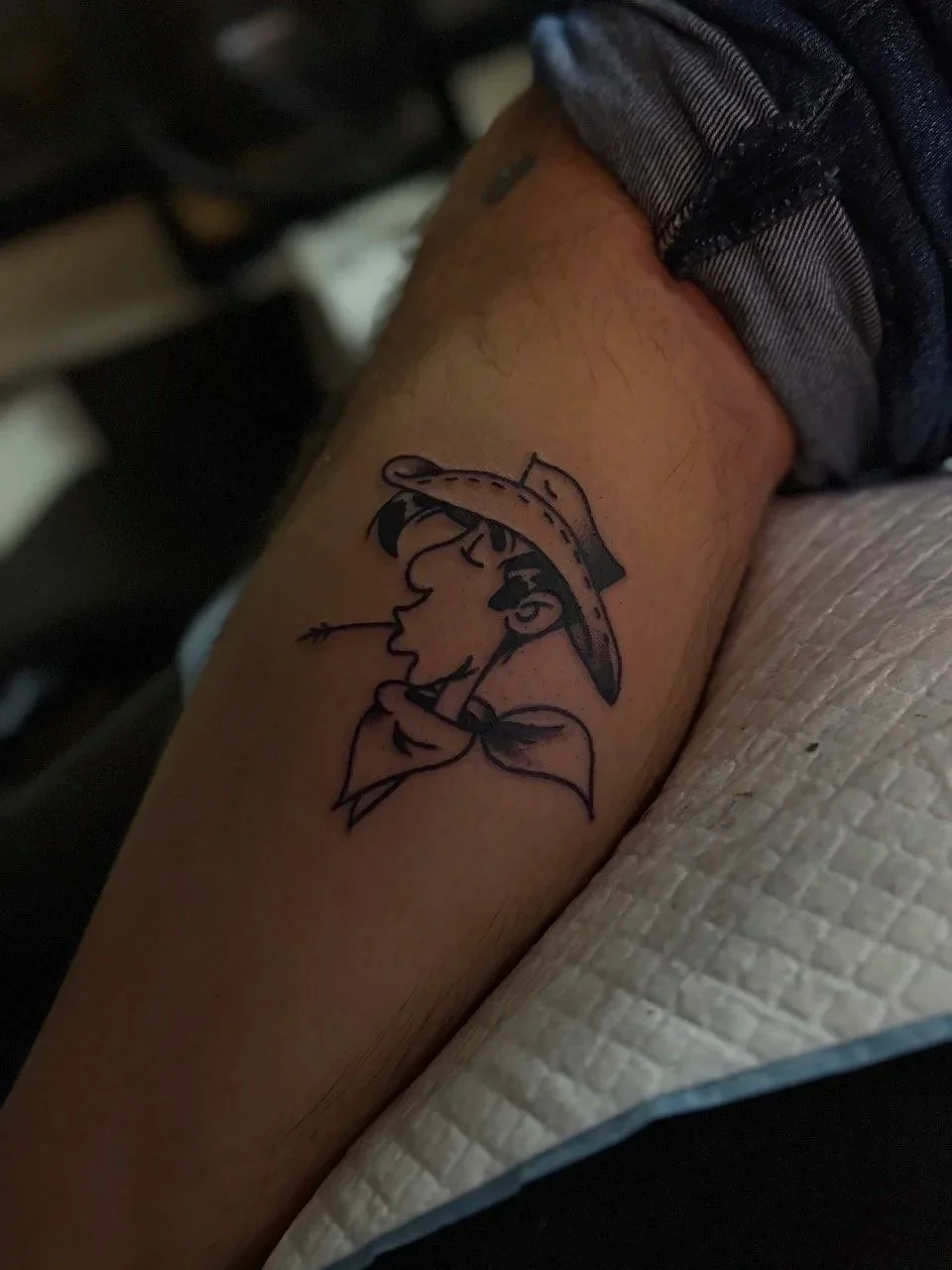 Tatouage d'une femme avec un chapeau dans le bras.