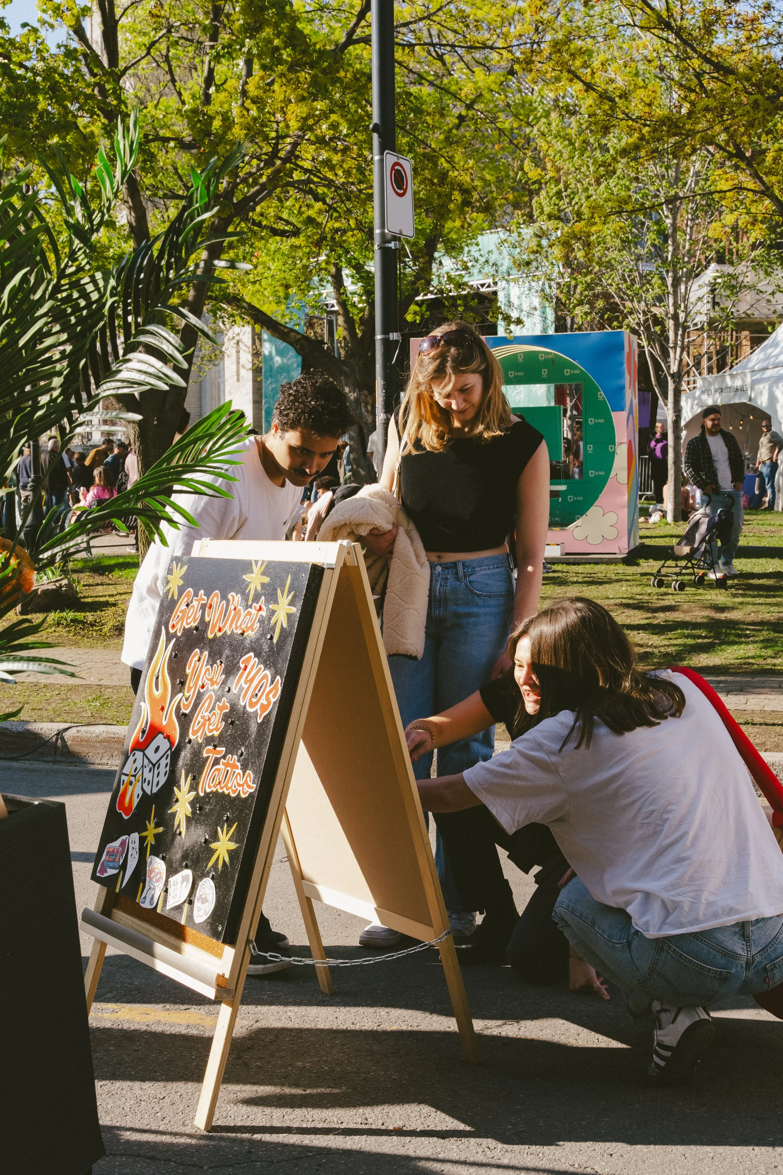 Des gens regardent le panneau, GET WHAT YOU GET, avec le sourire