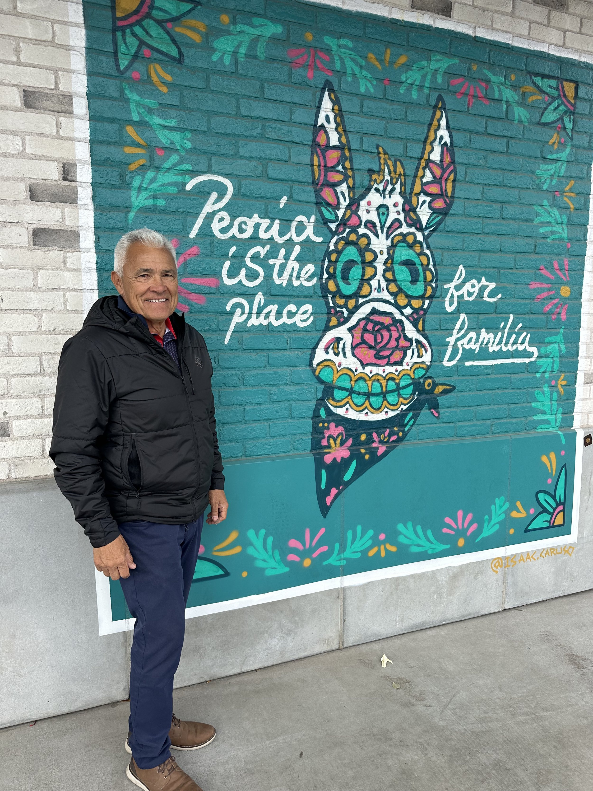 Art Miller standing in front of mural at Some Burros