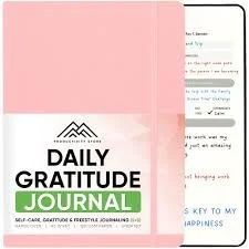 Daily Gratitude Journal with a pink cover and a partly visible screen showing gratitude prompts.