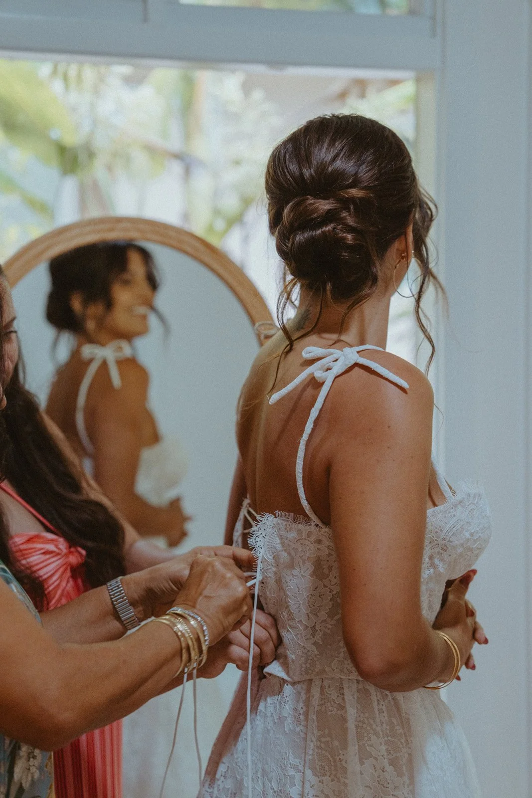 Bride with an elegant low bun hairstyle and natural, camera-ready makeup on her wedding day at Princeville, Kauai Airbnb. Photo by Brooke Stonely, Something Bleuu Photography.