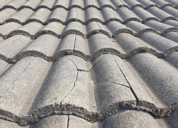 Damaged and cracked concrete roof tiles on an Auckland home requiring professional repair and tile replacement by Lux Roofing.