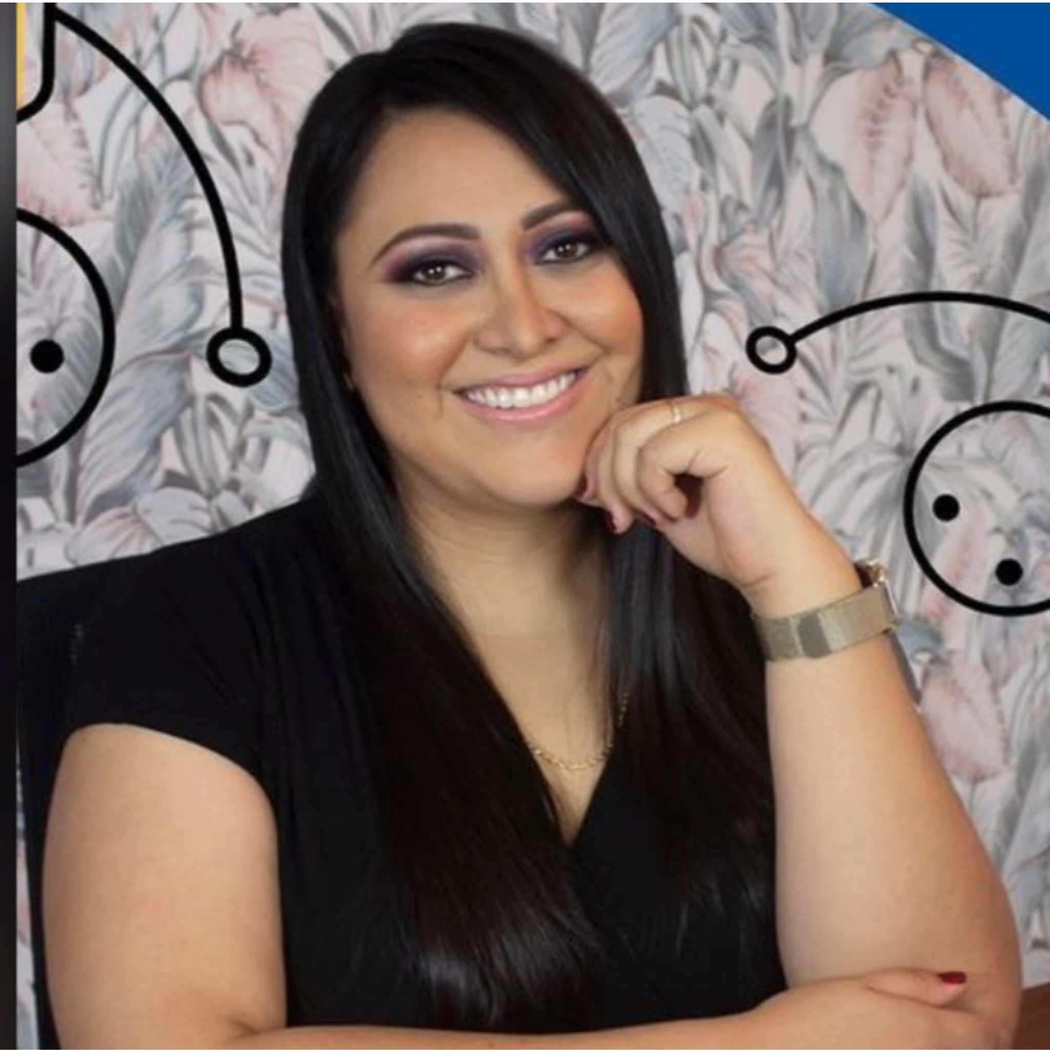 Mujer sonriente con cabello largo y oscuro, viste una blusa negra y lleva reloj y pulsera, en fondo con ilustraciones de botones y patrones florales.