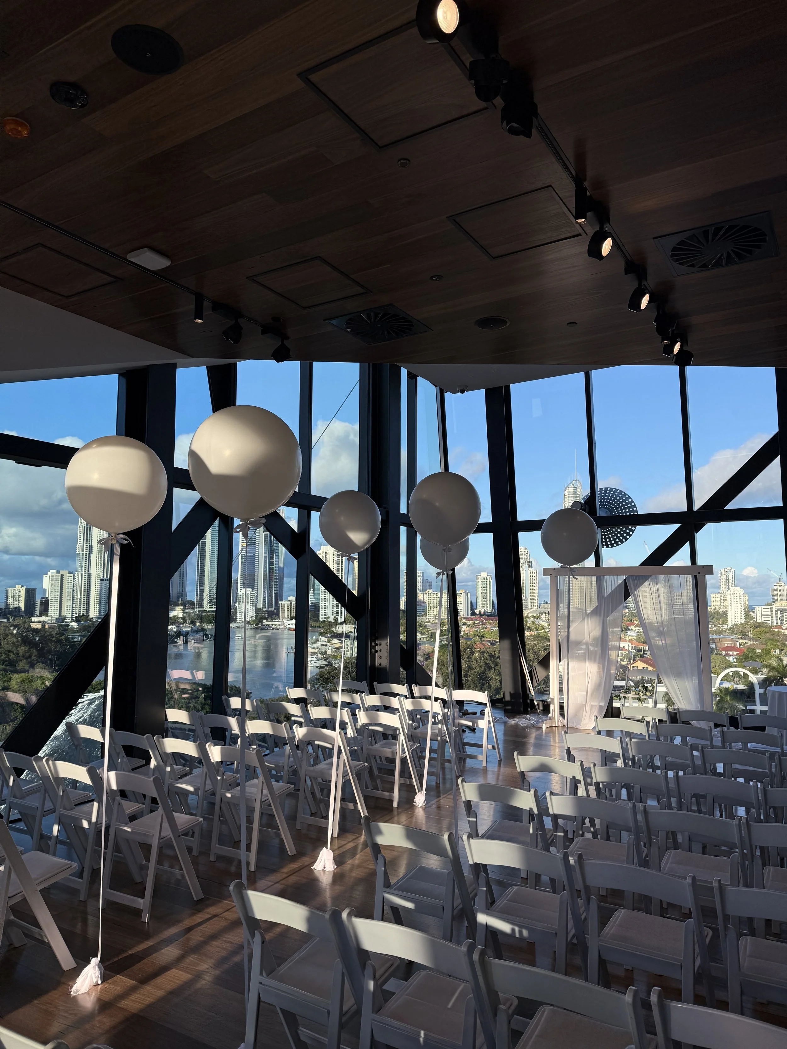 Wedding ceremony with isle lined with large white helium balloons on white ribbon.