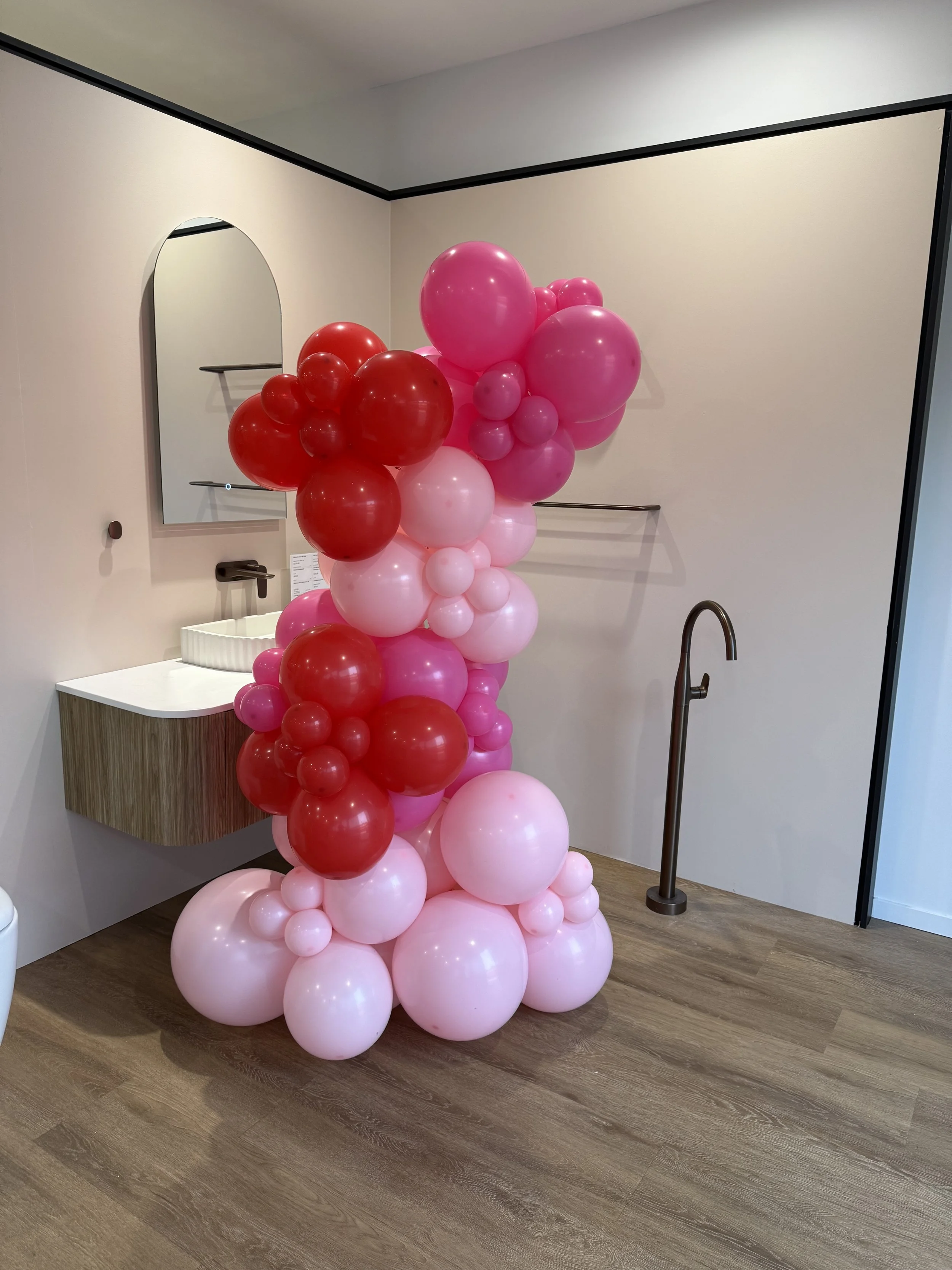 Arranged pink and red balloons forming a decorative column balloon garland perfect for any event.