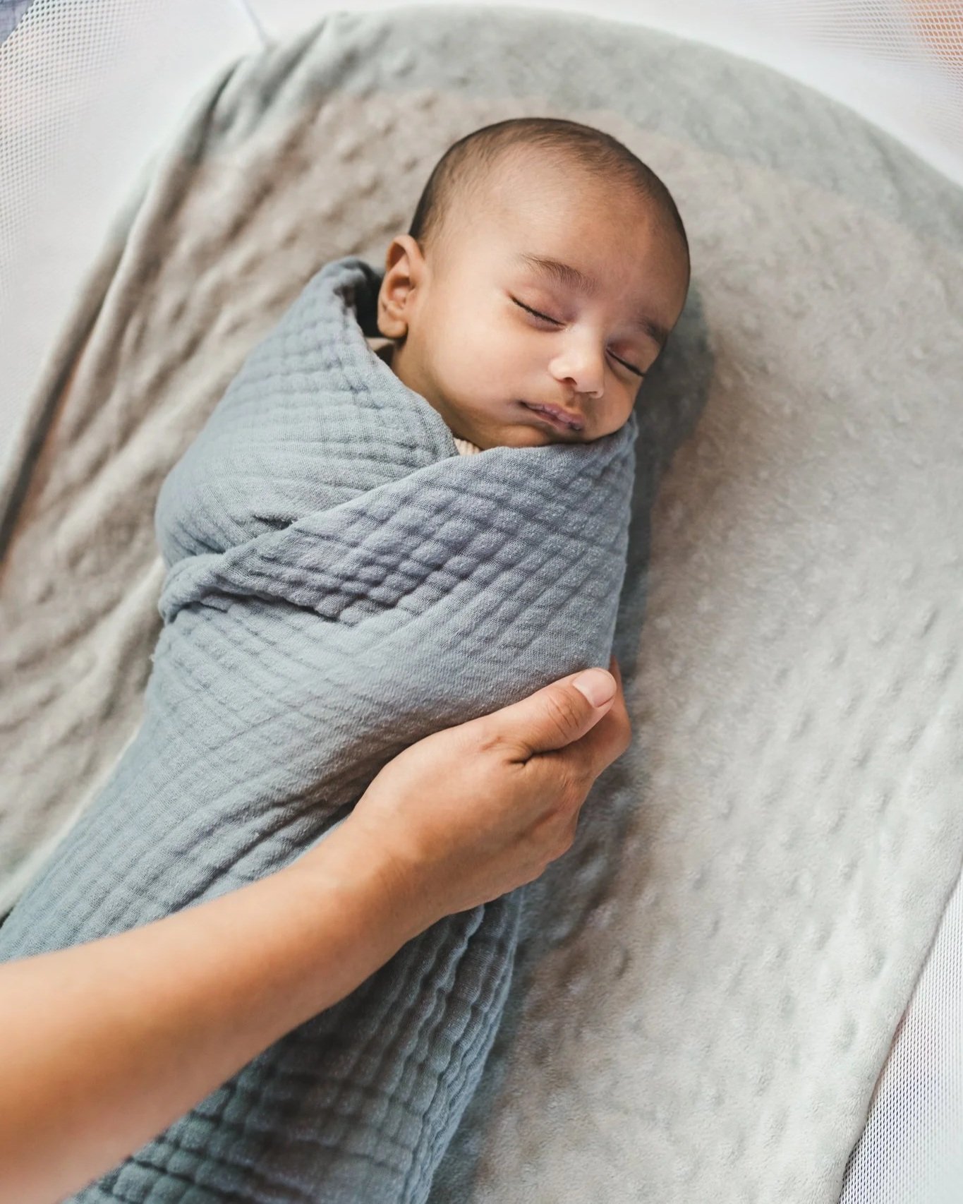 Sleeping newborn supported during overnight postpartum care