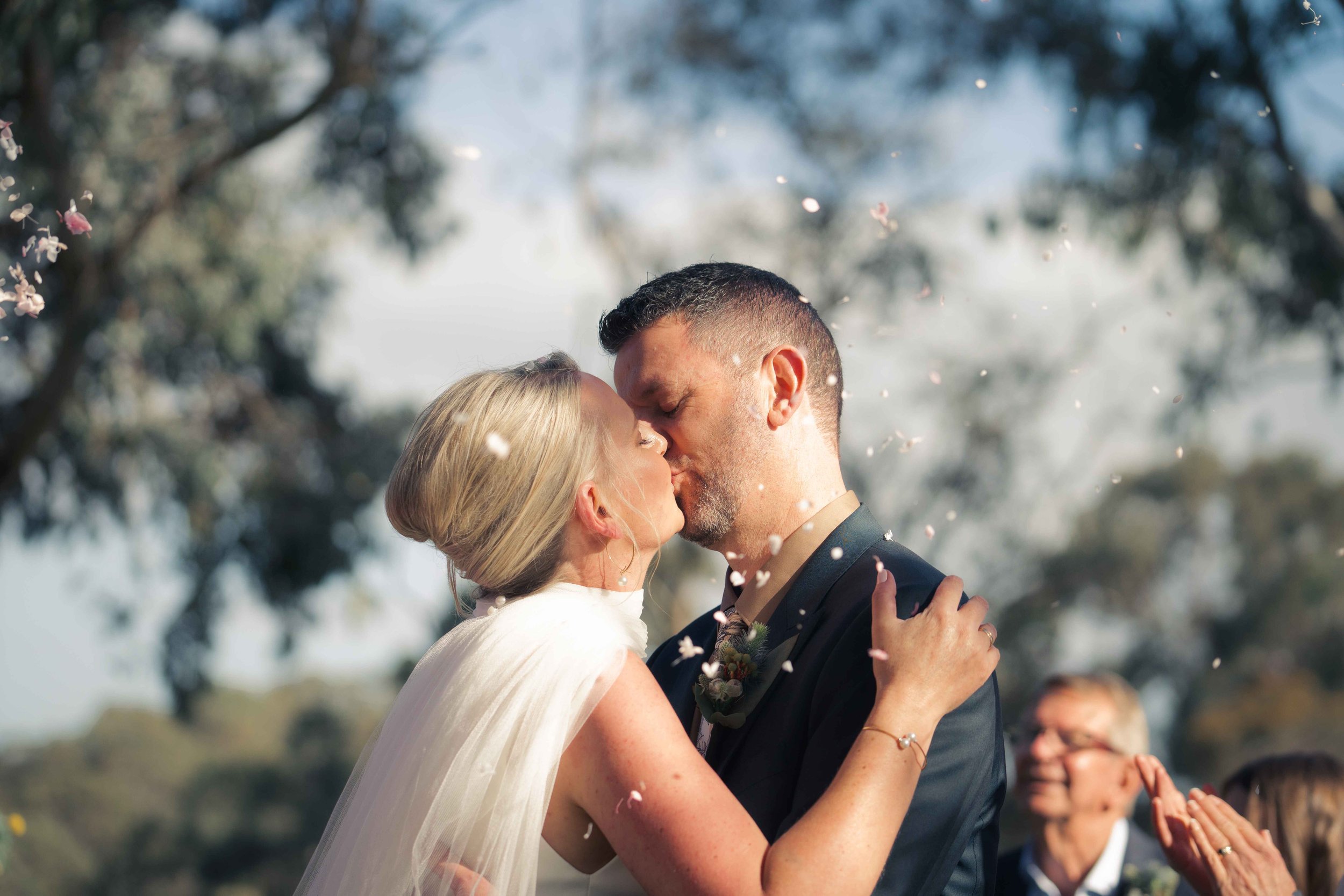 bride and groom kissing rose petals mature couple