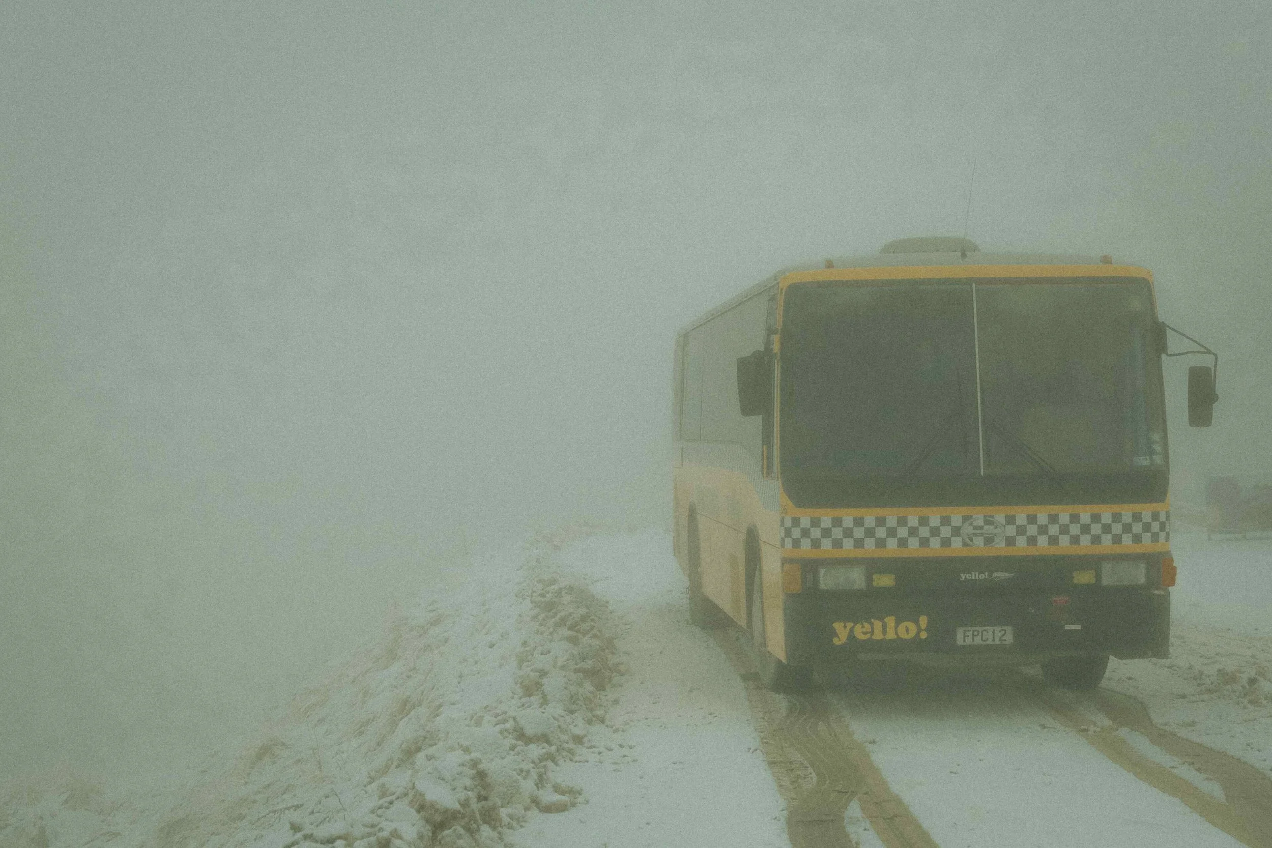 foggy snow New Zealand skiing travel yellow bus