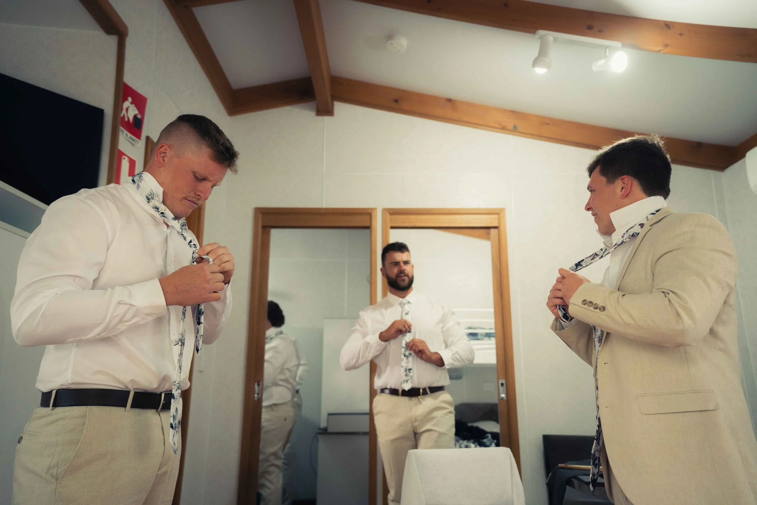 Groom and groomsmen preparation beige suits floral ties beige pants