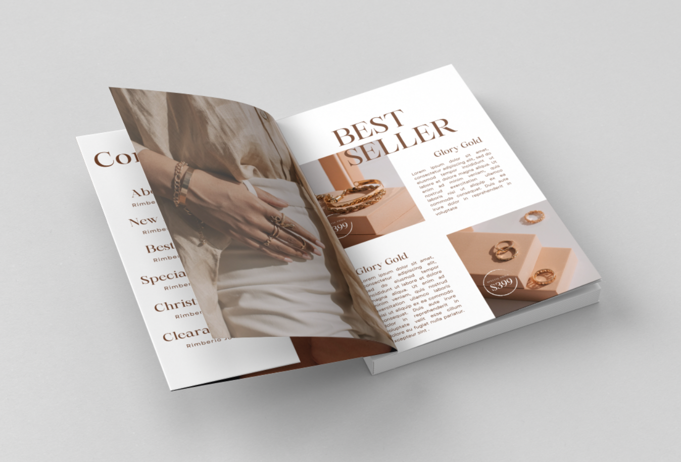 Magazine ouvert avec une page tournée, présentant des bijoux en or avec le texte 'BEST SELLER' et 'Glory Gold'. Une personne portant des bijoux est visible sur la page tournée. Arrière-plan gris clair.