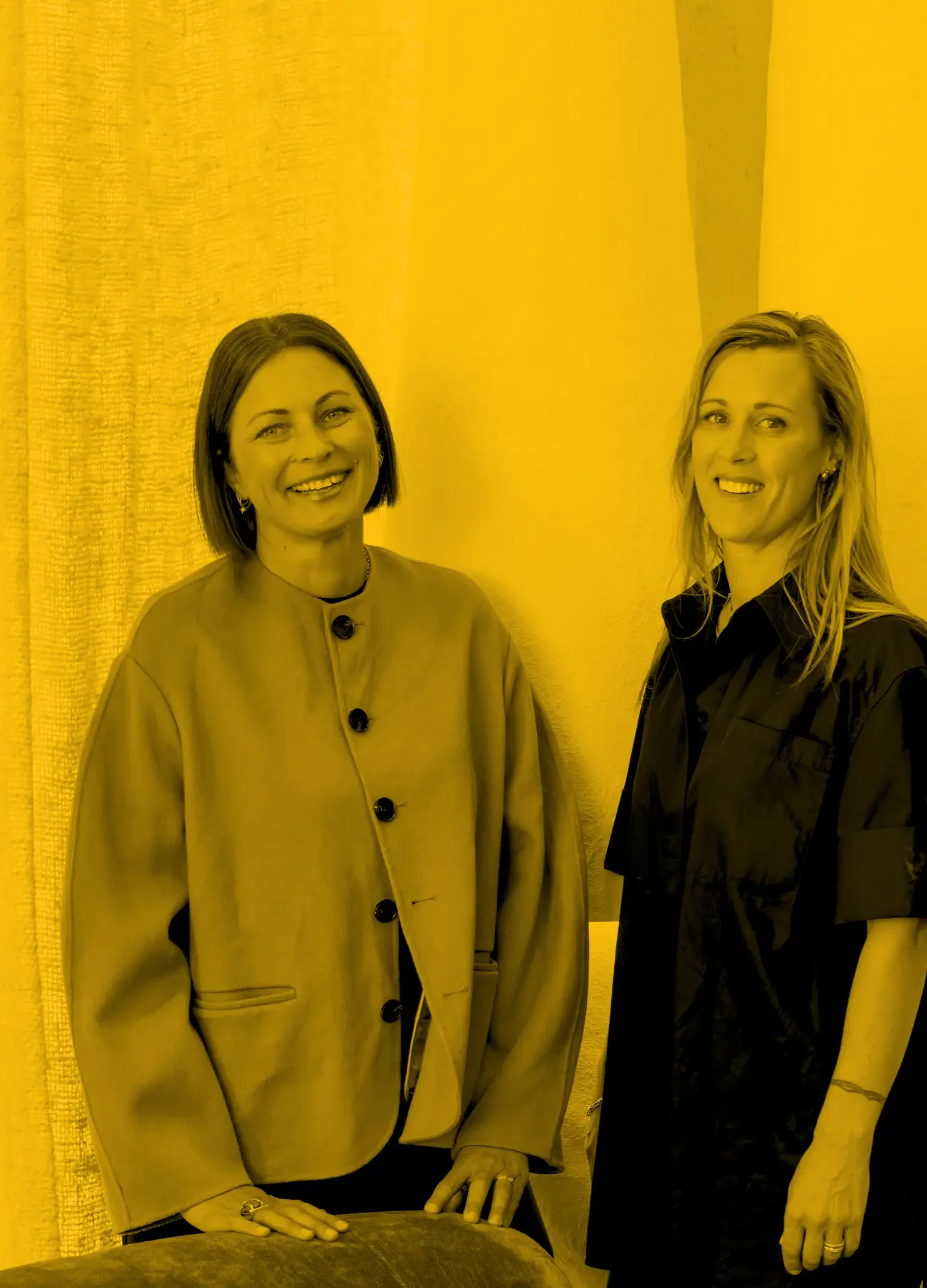 Assembl Studio founders photographed in a warm modern interior with textured furnishings and neutral styling.