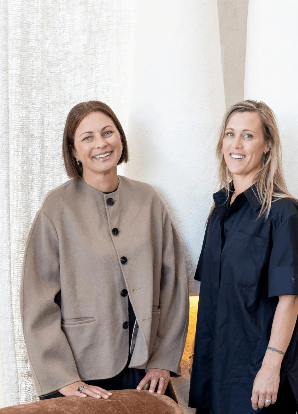 Assembl Studio founders photographed in a warm modern interior with textured furnishings and neutral styling.