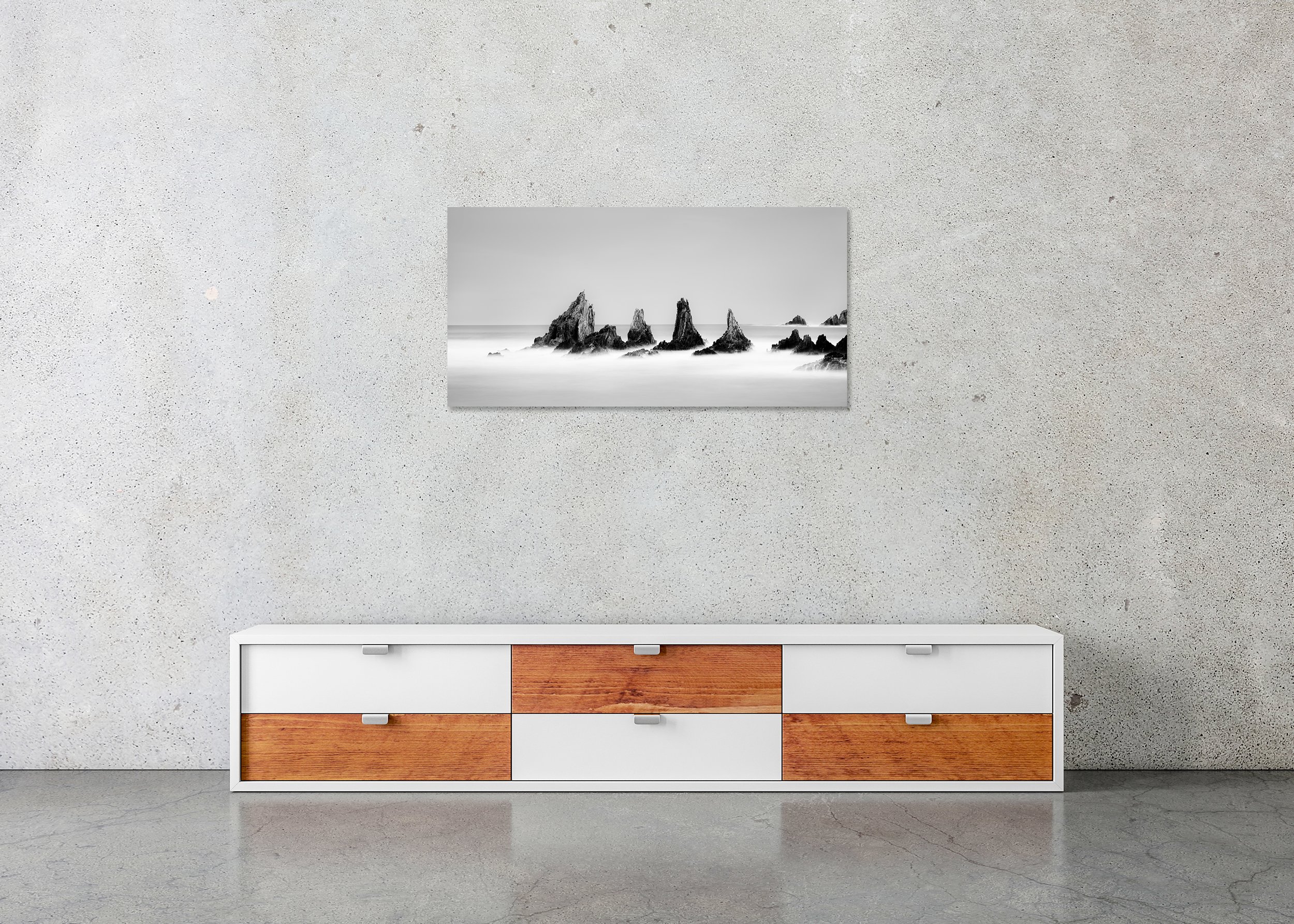 Long-exposure black-and-white ocean scene with jagged rocks, smooth misty water and clear sky, as a ChromaLuxe metal print with a frameless finish.