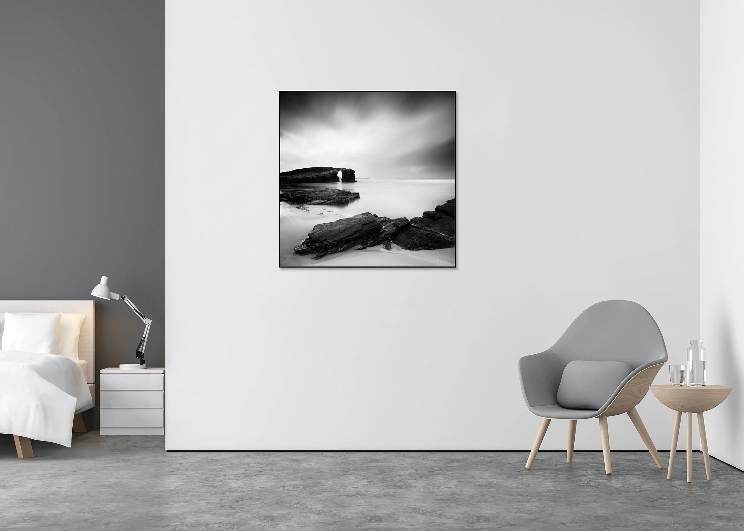 Monochrome coastal photograph of a natural rock arch and rocky beach with calm water under an overcast sky, mounted to Dibond in an aluminium ArtBox.