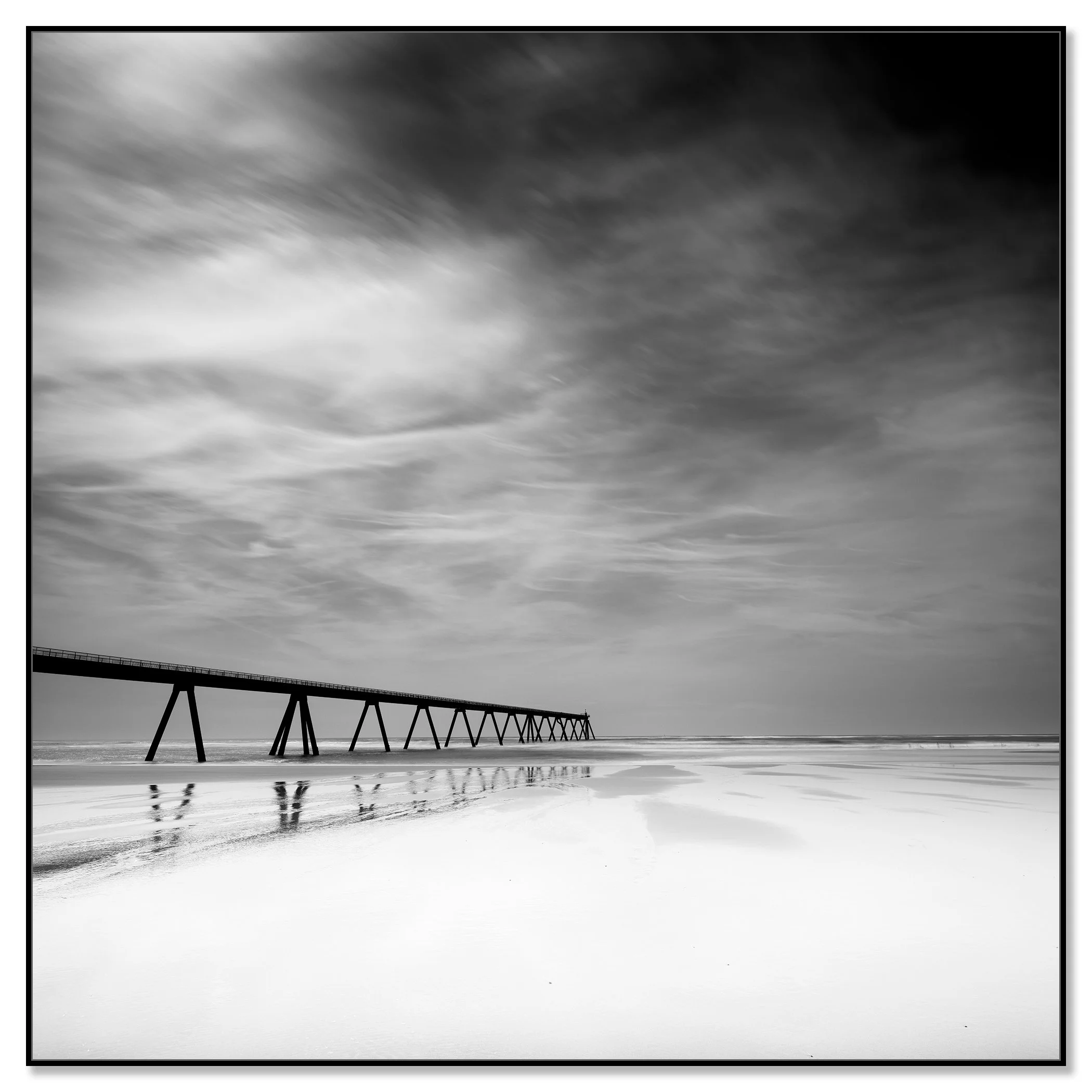 Framed black-and-white seascape photograph of Wharf de la Salie, France, in a black aluminium ArtBox frame