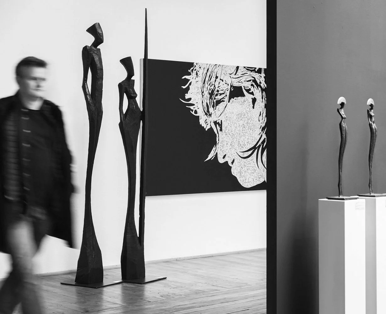 German sculptor Nando Kallweit with his figurative bronze sculptures in an exhibition setting.