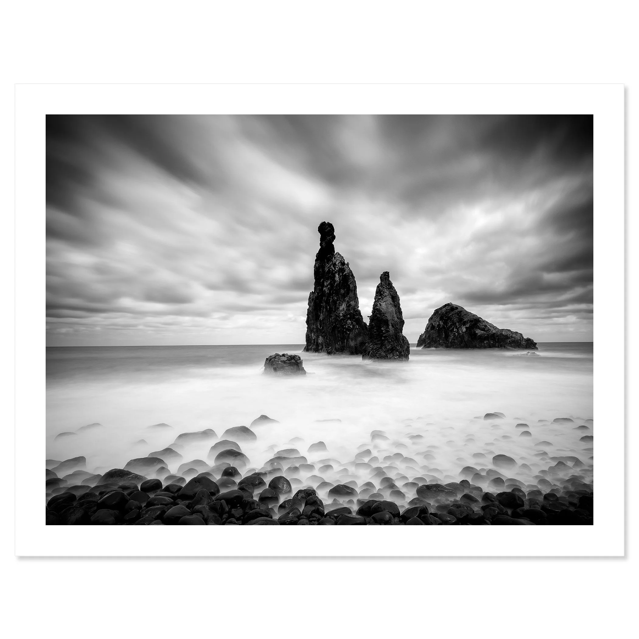 © 2021 Gerald Berghammer - Black and white seascape photography. Rocky seashore with three prominent sea stacks rising from the water, cloudy sky overhead. Fine art print only