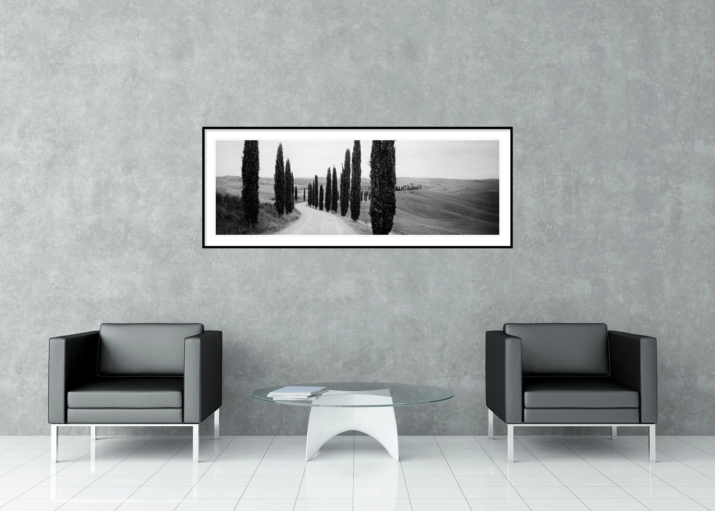 Black-and-white photo of a winding Tuscan road lined with tall cypress trees through rolling hills, archival pigment print in a classic frame with mount.