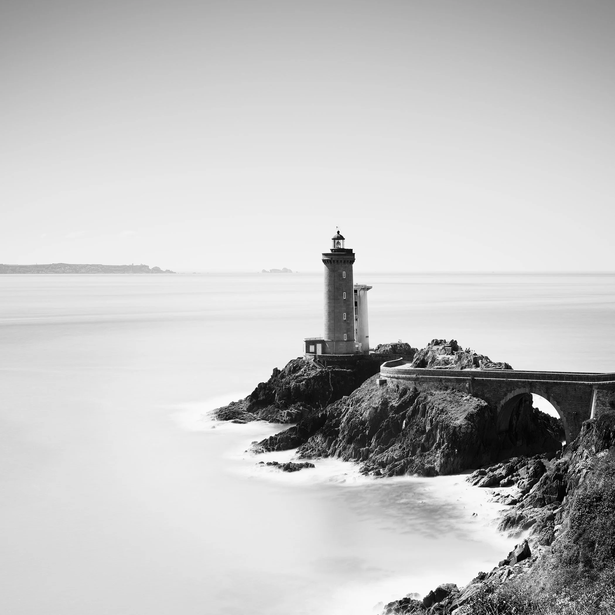 Black-and-white long exposure of Phare du Petit Minou lighthouse on a rocky coast in Brittany, France