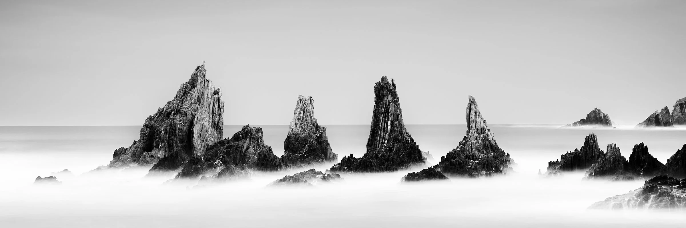 Rocky Peaks, Panorama Study 3 – panoramic black-and-white seascape of jagged Atlantic rock formations in Spain by Gerald Berghammer.