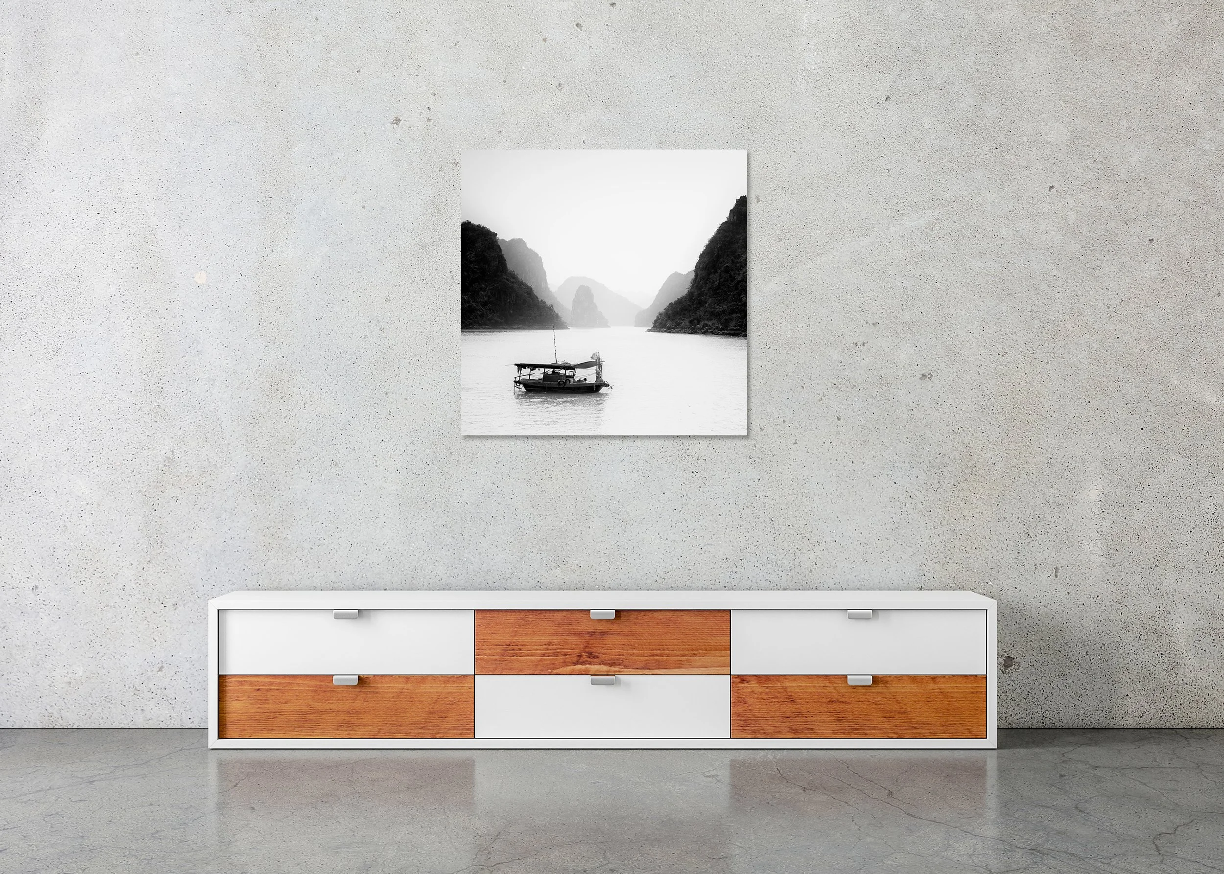 Black-and-white photograph of a small boat on calm water among misty limestone karsts in Ha Long Bay, Vietnam, photo print mounted to Dibond, frameless.