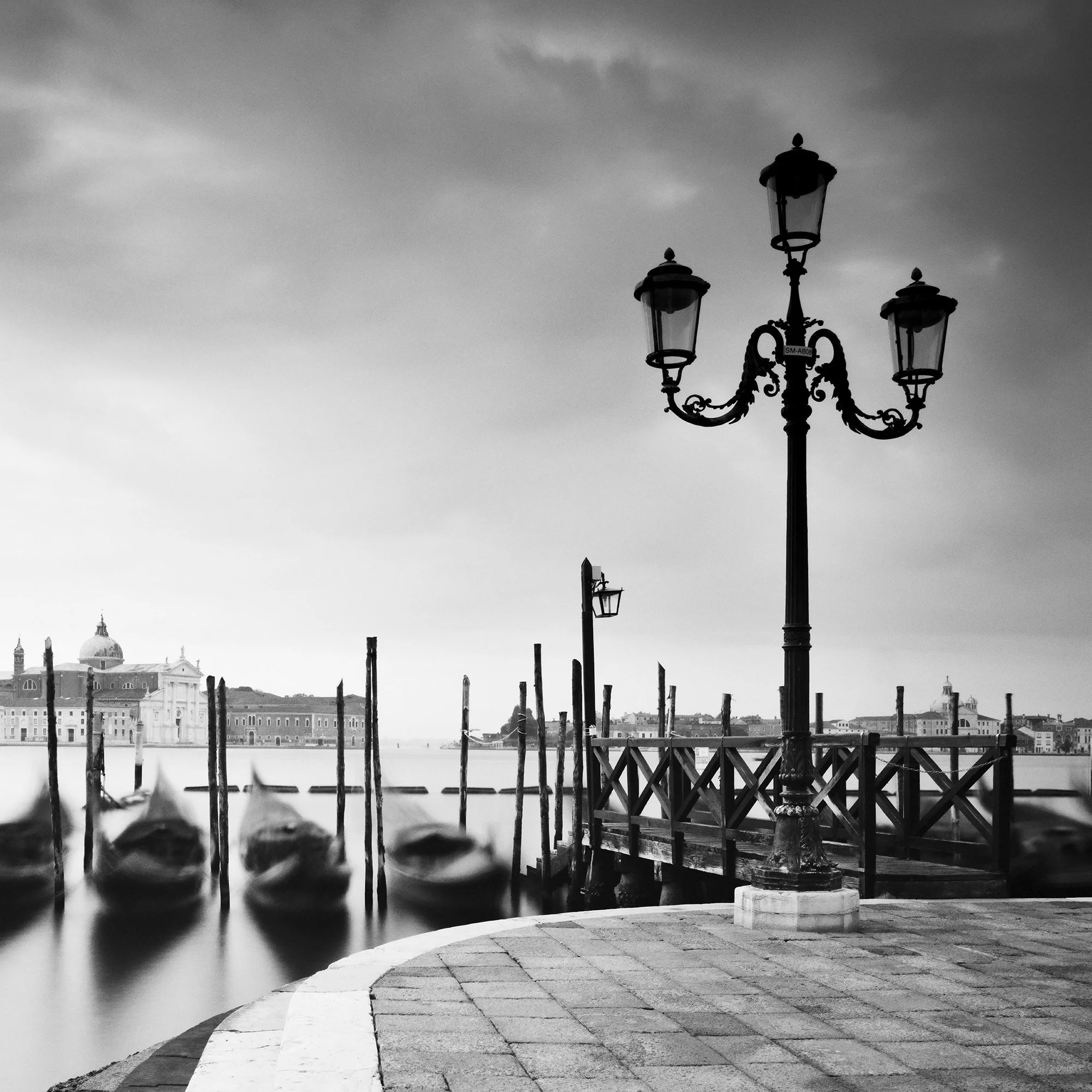 Detail view of gondolas and San Giorgio Maggiore in Gerald Berghammer black-and-white Venice photograph
