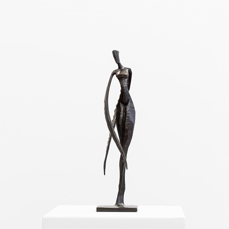 Nelia by Nando Kallweit, limited-edition figurative bronze sculpture of an elongated female form presented on a white pedestal.