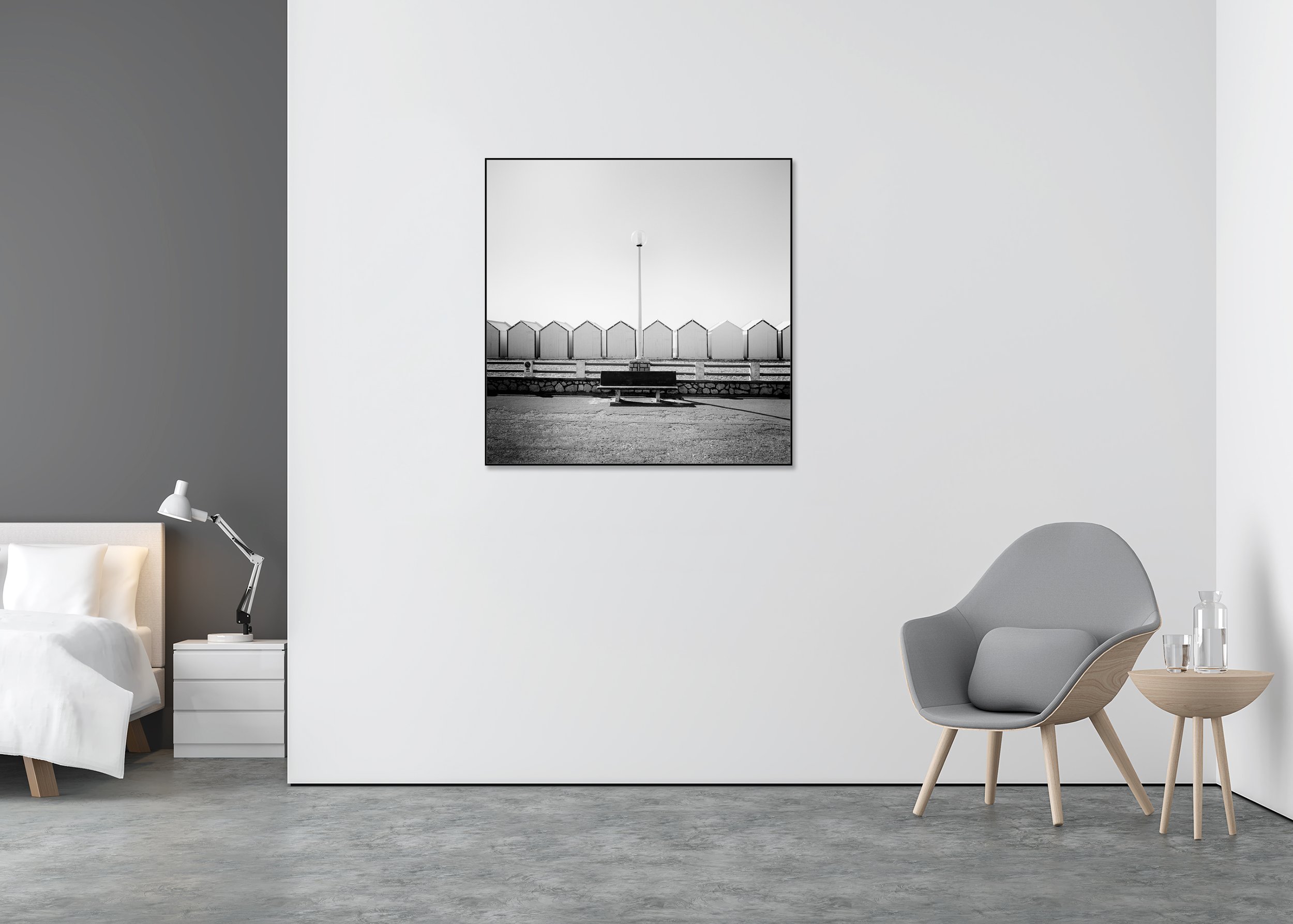 Black-and-white coastal photograph in France with an empty bench and centred streetlamp in front of geometric beach huts, ChromaLuxe metal print in Aluminium ArtBox.