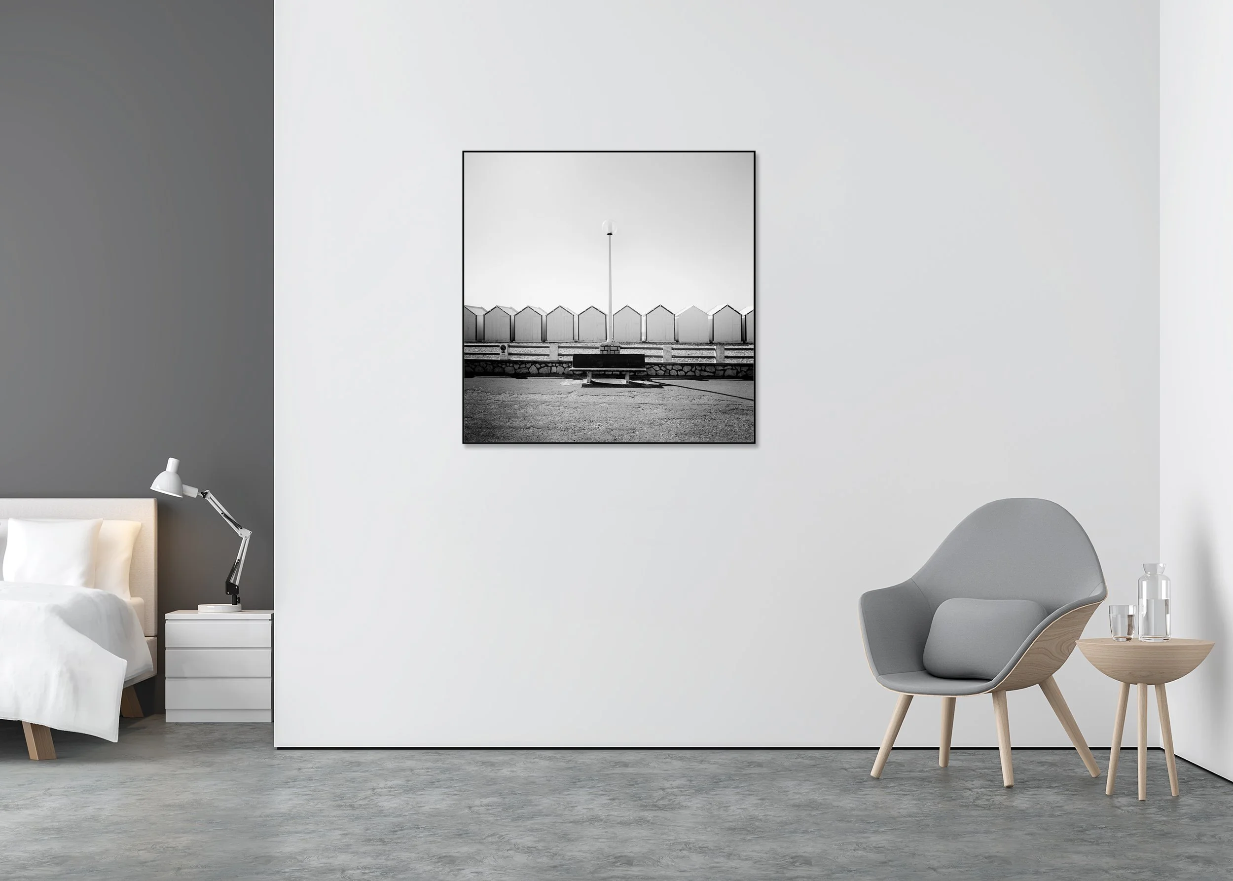 Black and white coastal wall art with empty bench and centred street lamp before geometric beach huts, photo print mounted on Dibond in aluminium ArtBox.