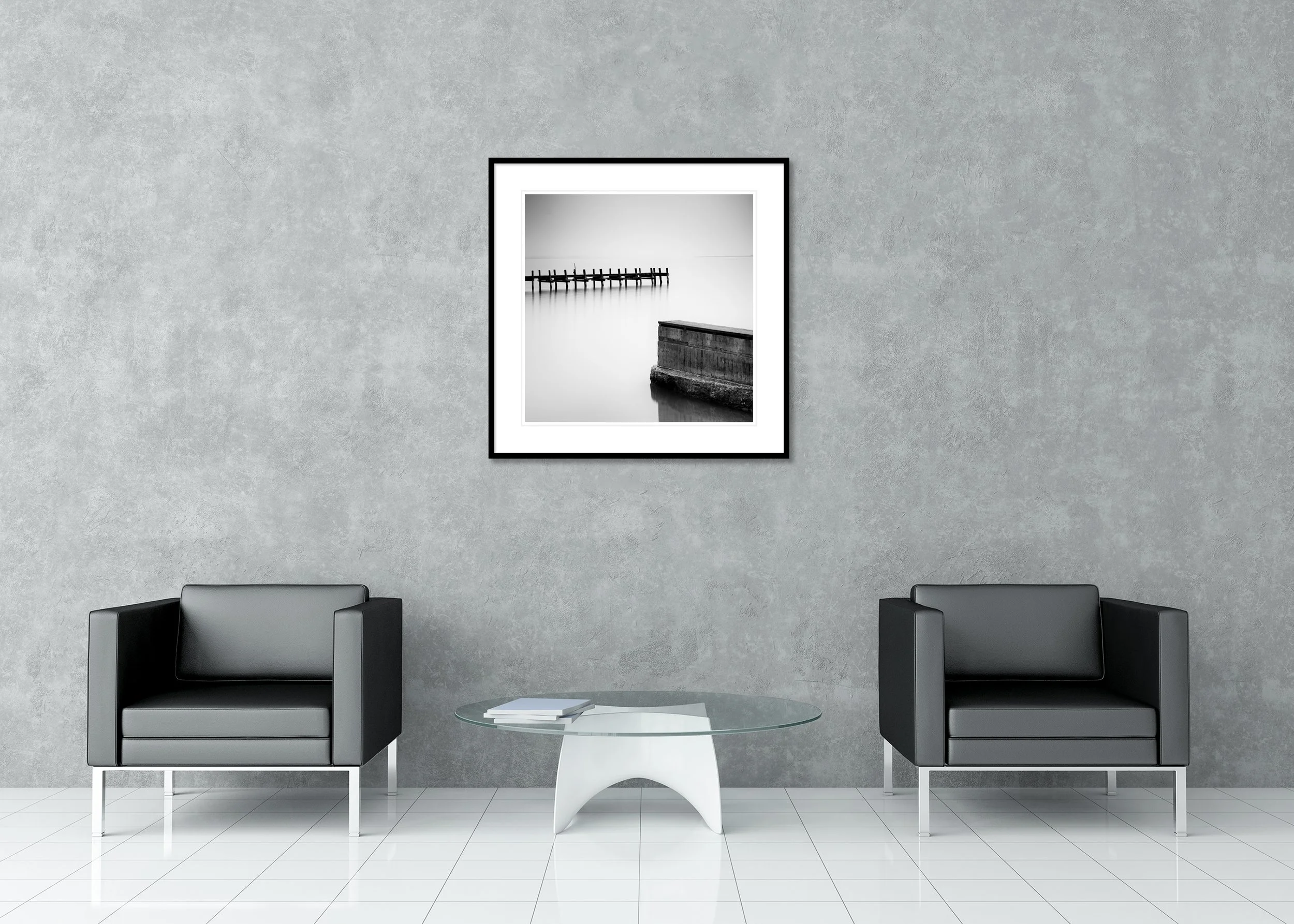 Black and white archival pigment print of an old wooden pier over still water in a minimalist landscape, framed with a classic mount