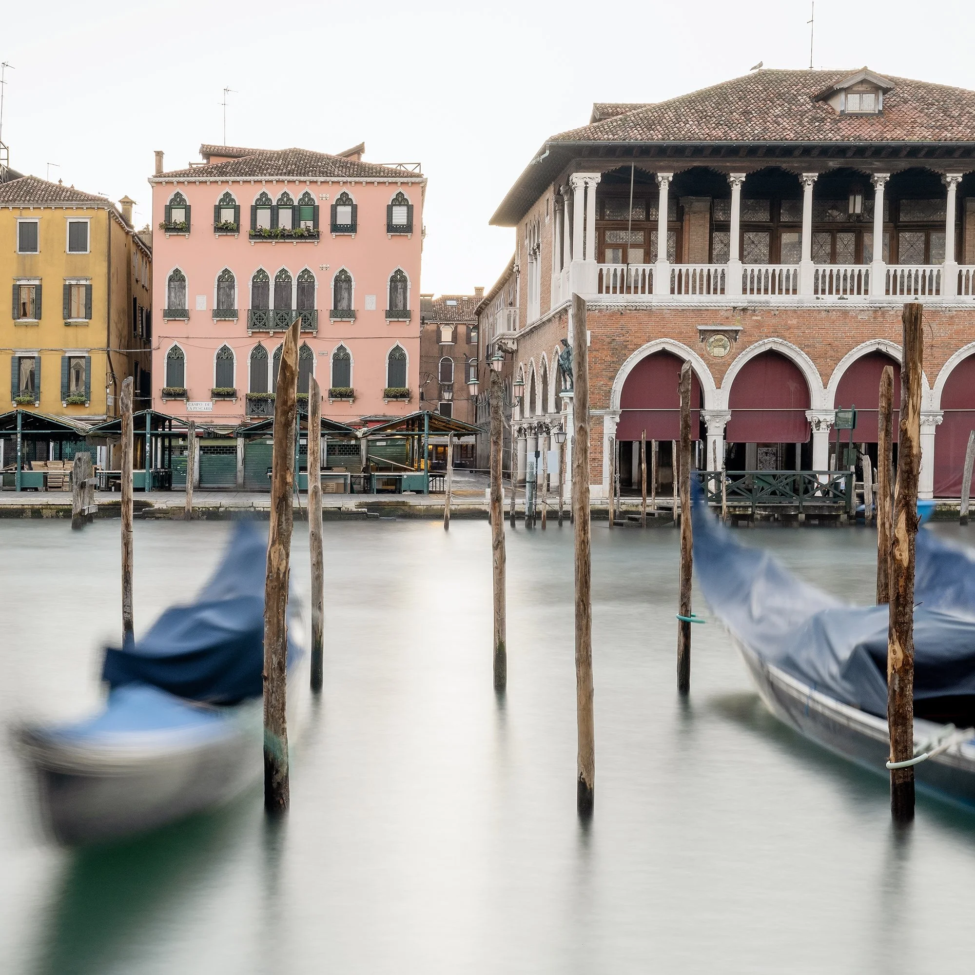 © 2025 Gerald Berghammer - Color cityscape photography. Gondolas docked along a canal in Venice, Italy, with historic buildings and the fish market in the back. Print detail 3