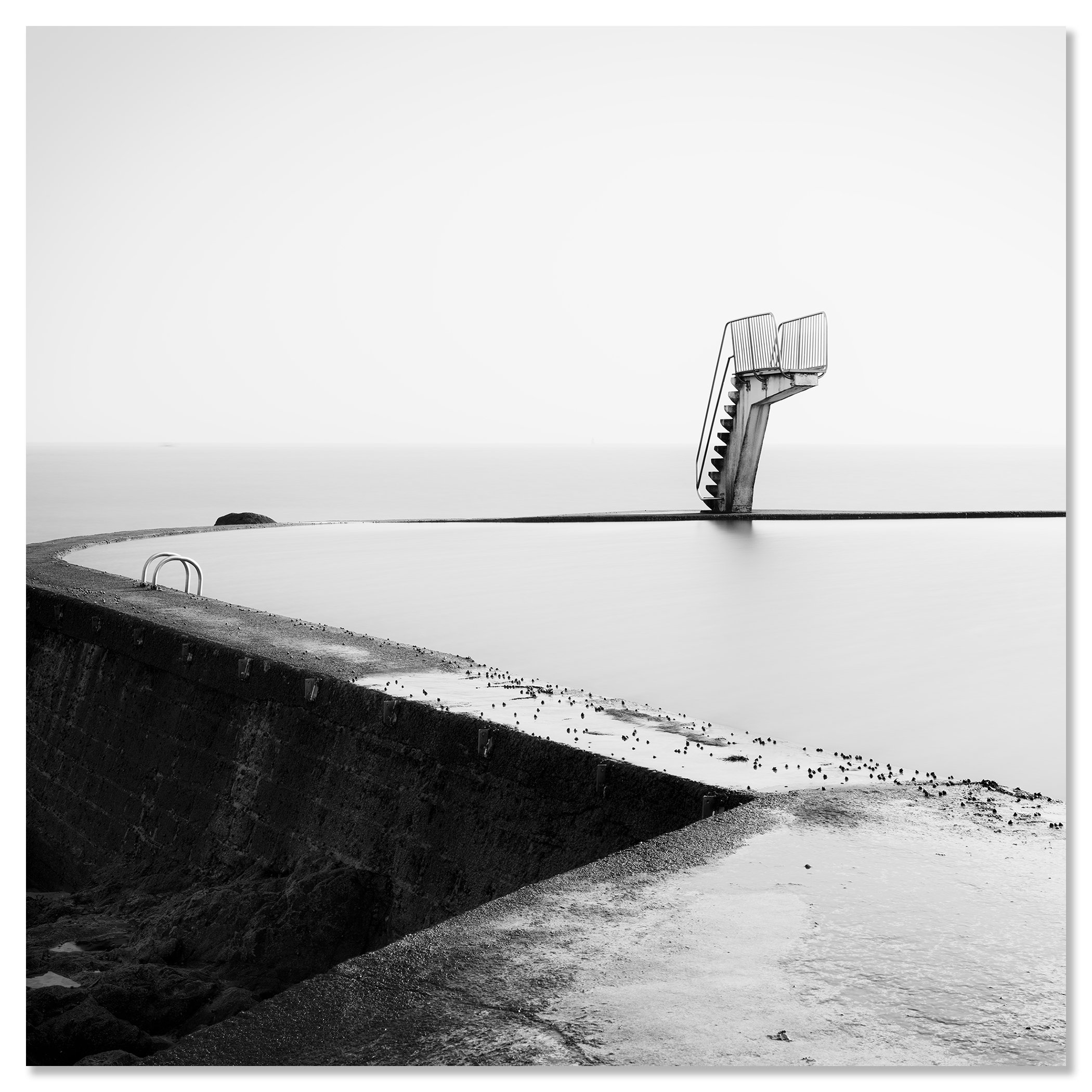 Empty diving platform in a quiet seawater pool on the coast, captured in black and white – dibond frameless