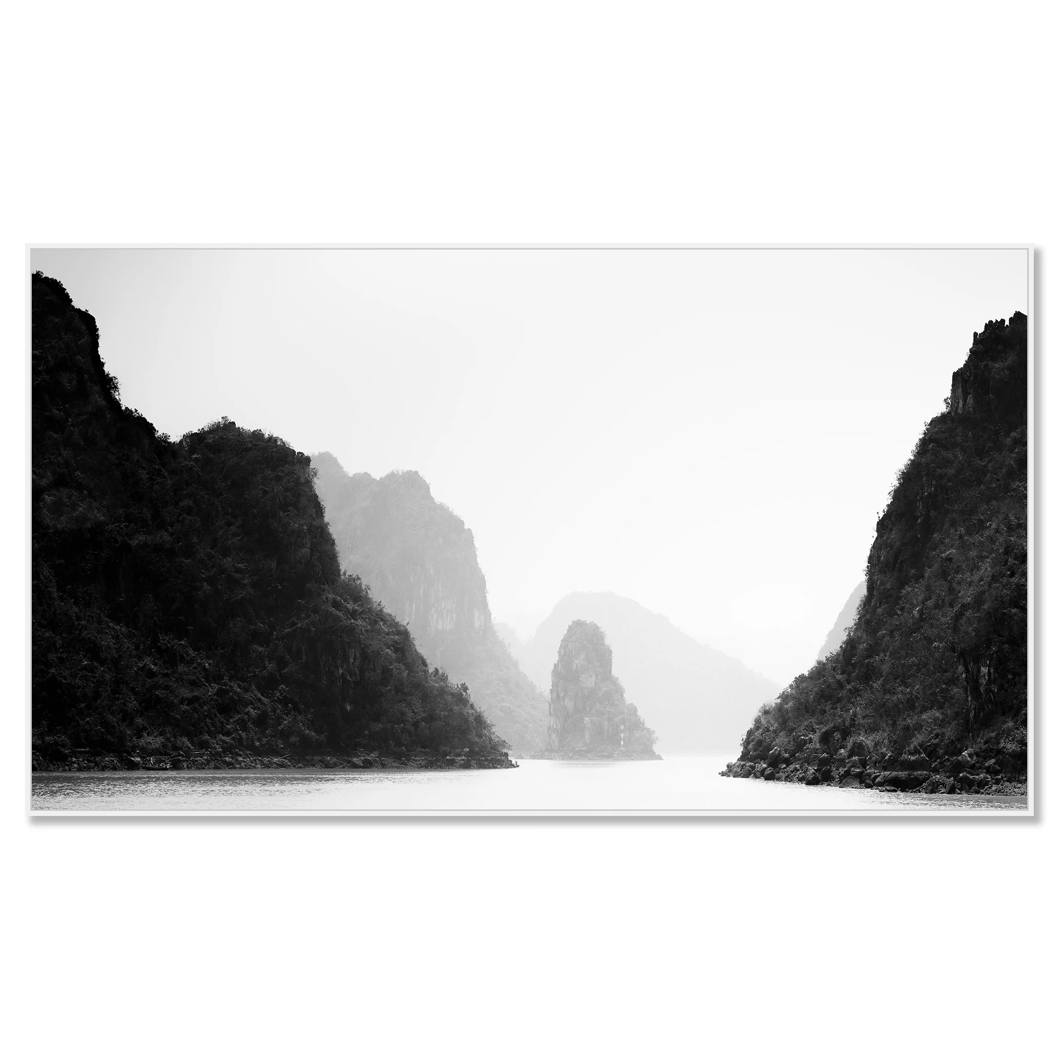 Black-and-white photo of calm water between steep limestone cliffs with misty mountains in the background – framed ArtBox white
