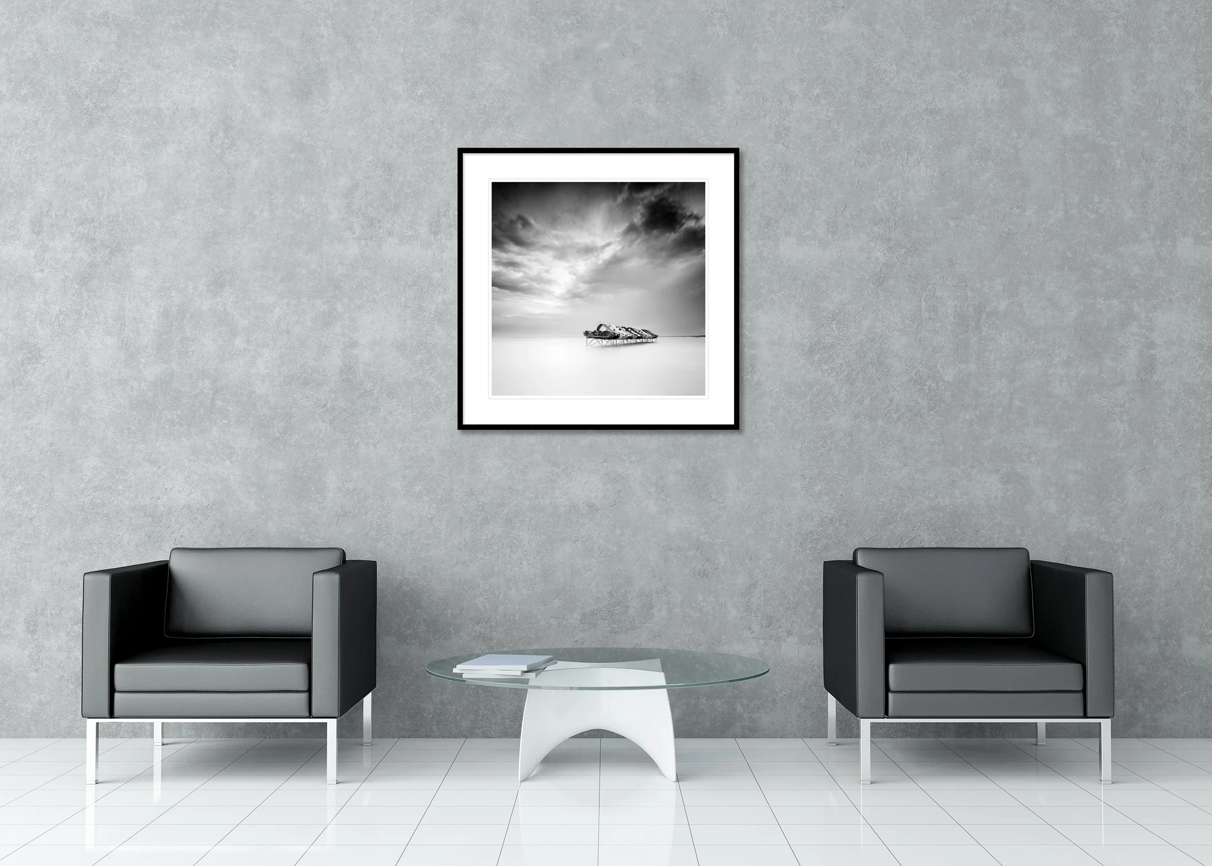 Black and white long-exposure photo of pedal boats on stilts in calm water beneath a cloudy sky, archival pigment print in a classic frame with mount.