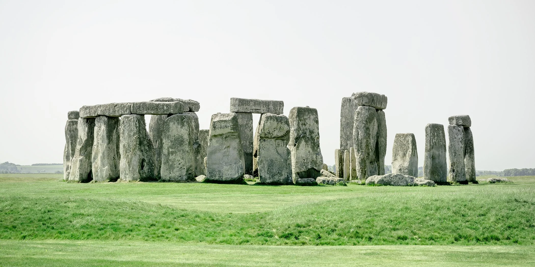 Panoramic colour photograph of Stonehenge in a green landscape in Wiltshire, England. Photo by Gerald Berghammer.