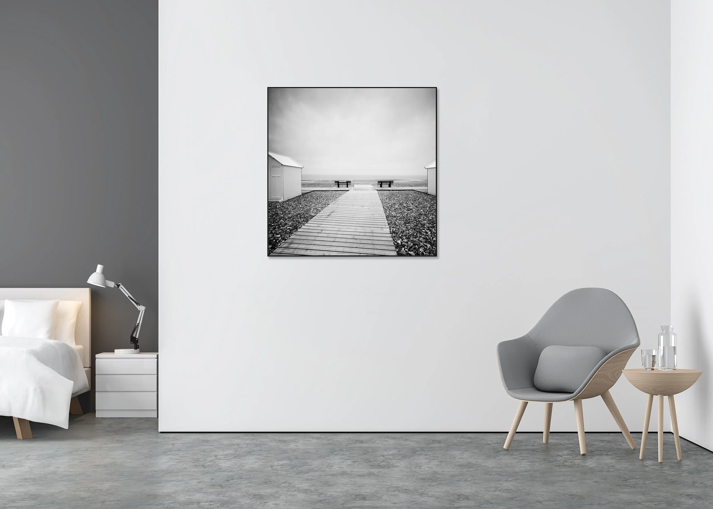 Black and white photo print of a wooden path on a shingle beach between white beach huts, mounted on Dibond in an aluminium ArtBox frame.