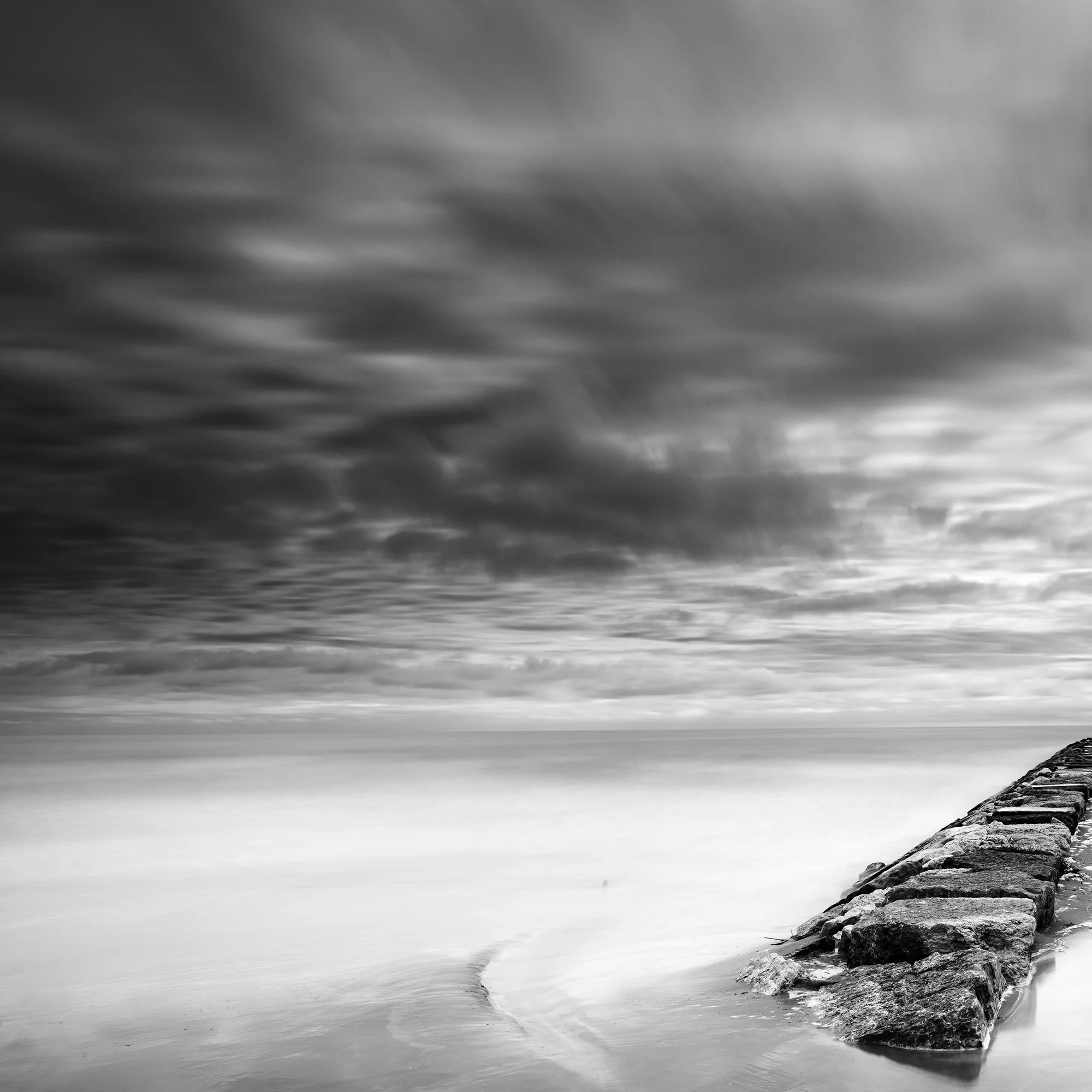Rock Pier, Panorama Study 1 by Gerald Berghammer, detail of dark cloud formations and the stone breakwater on the Italian coast.