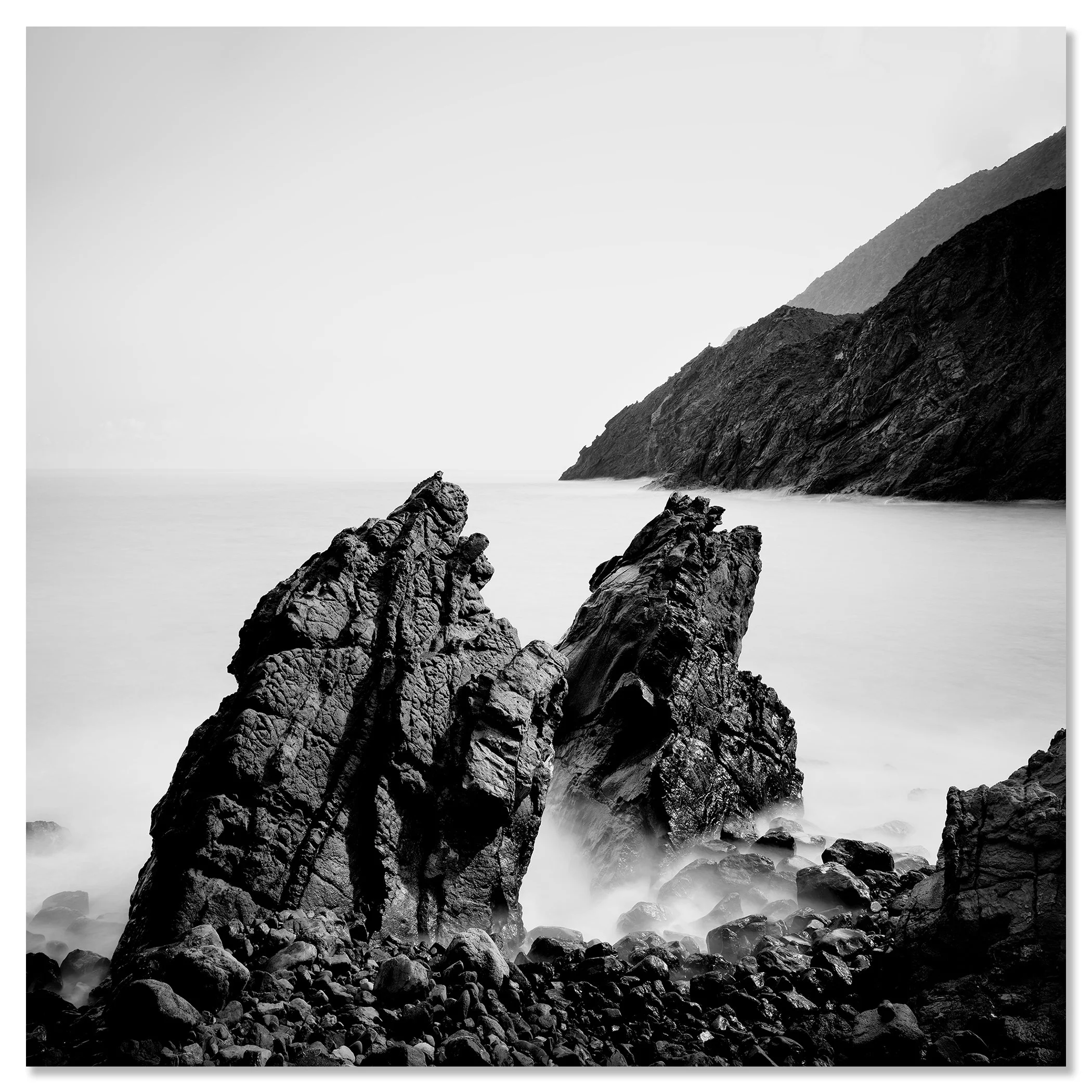 Black and white Atlantic seascape: rocky shoreline, large sea boulders, and mountains in the distance – dibond frameless