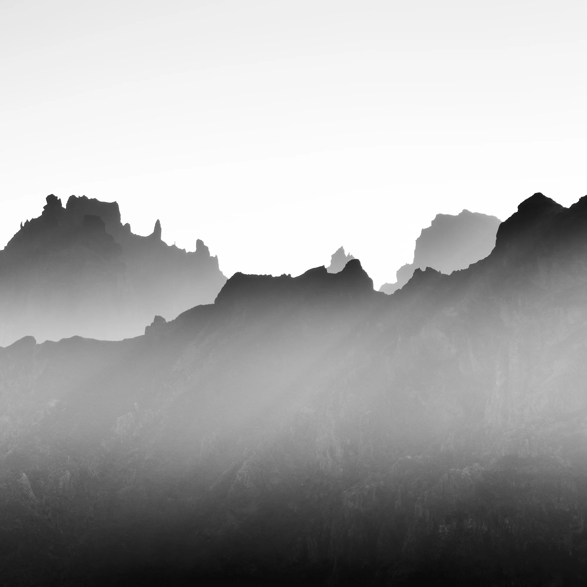 Detail of Mountains in Shadow with Morning Light by Gerald Berghammer showing layered mountain peaks emerging through mist.