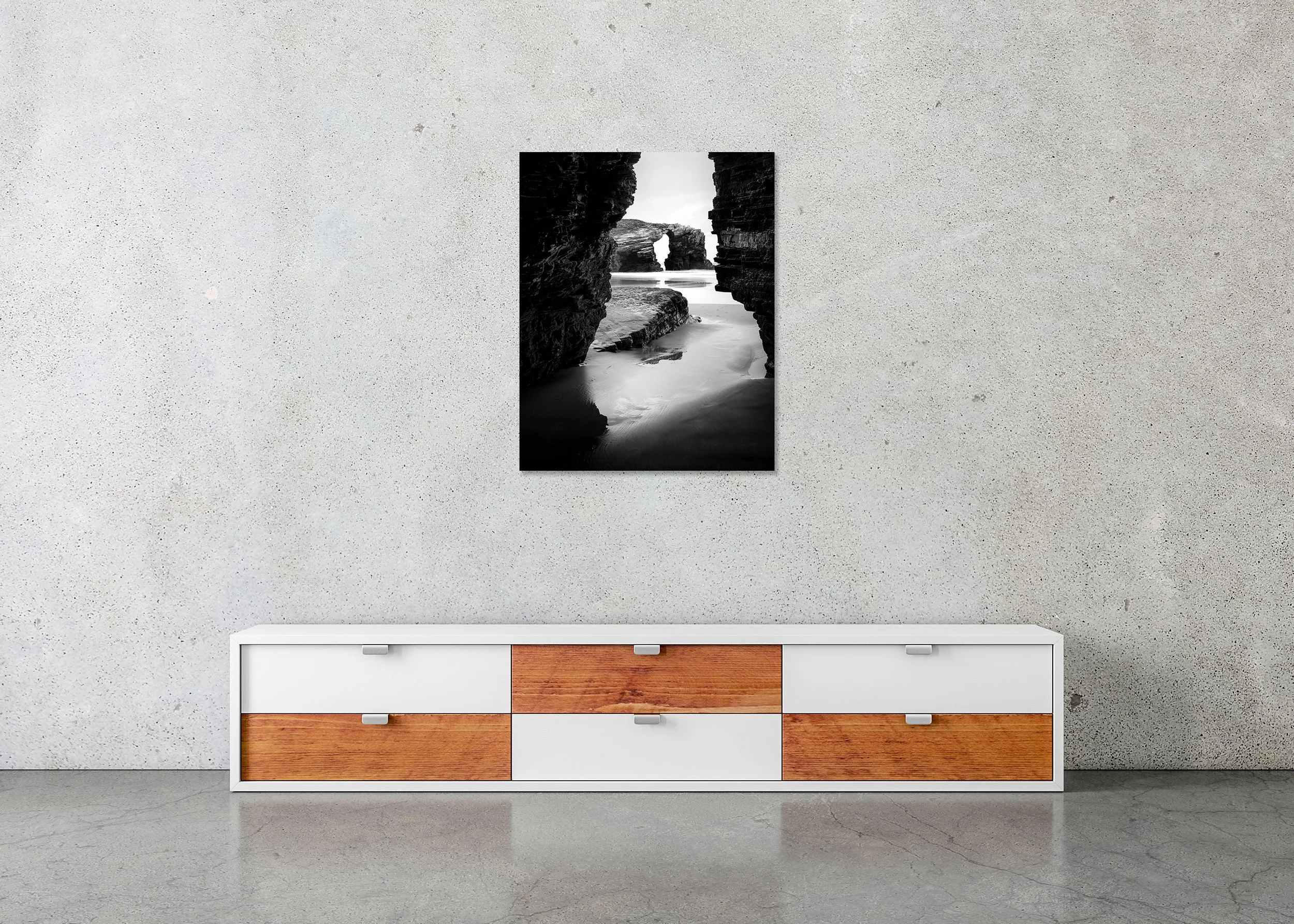 Black and white coastal landscape with rocky shore and natural arch seen through a narrow rock opening with sea beyond ChromaLuxe metal print frameless.