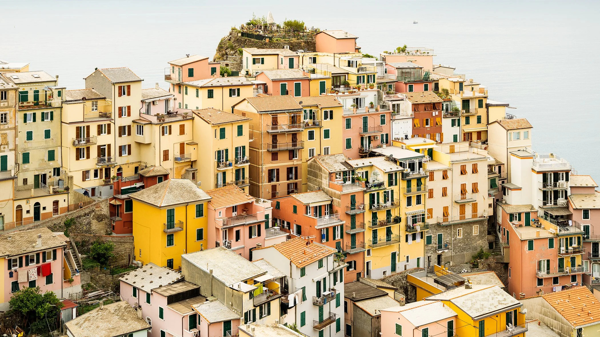 Pastel buildings stacked on a steep hillside in Cinque Terre, Italy