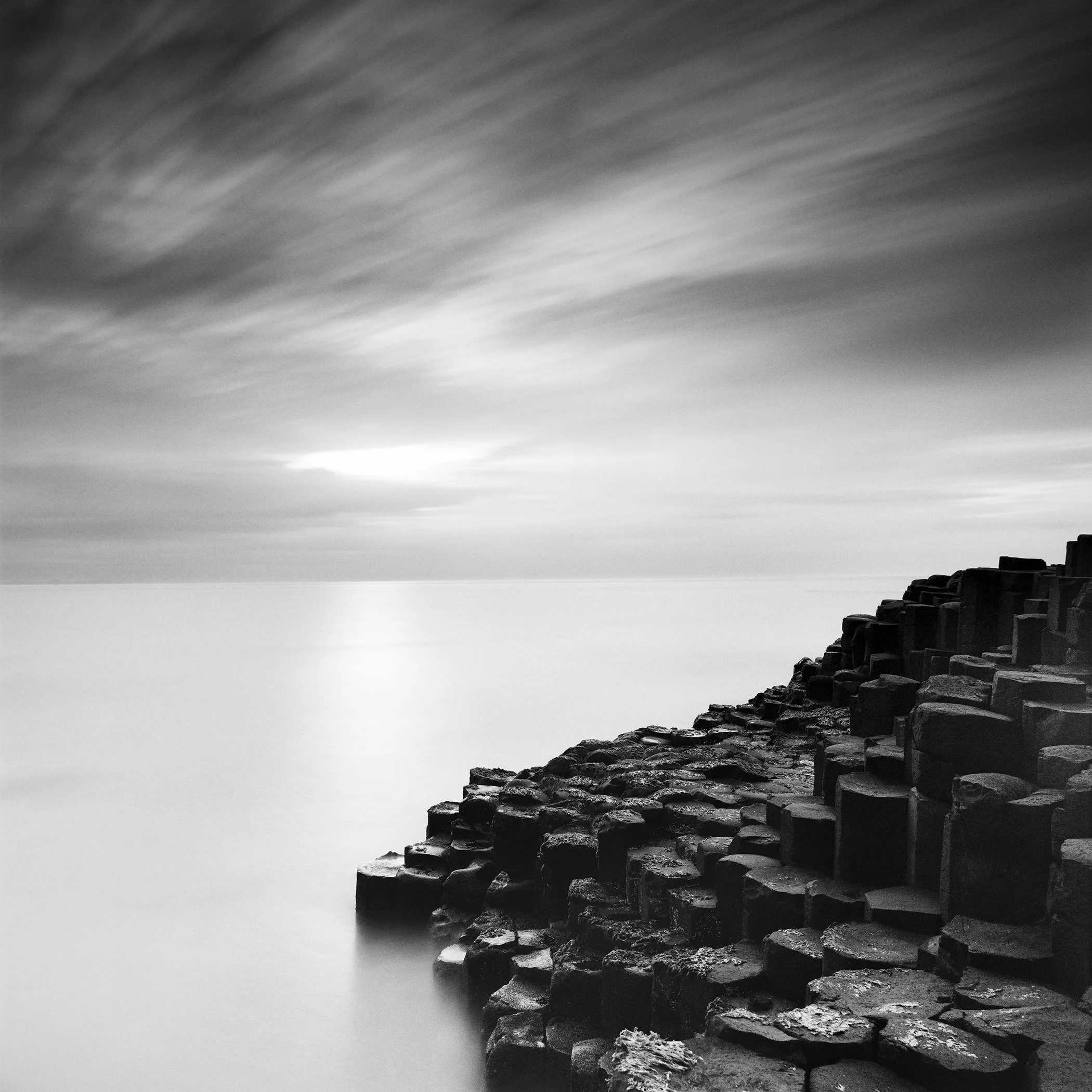 Giant’s Causeway Study 3 by Gerald Berghammer, minimalist black-and-white long-exposure photograph of basalt columns and the calm sea in Northern Ireland.