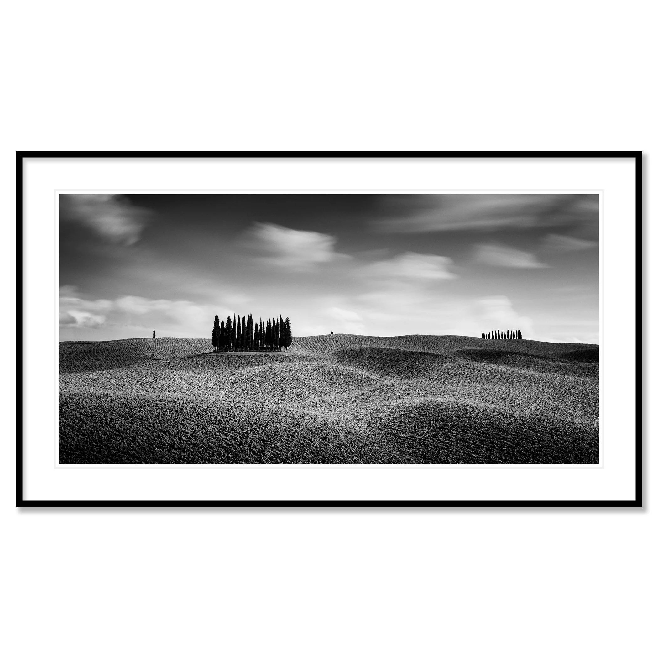 © 2020 Gerald Berghammer - Black and white Tuscan landscape photography. Rolling hills with two clusters of tall, thin trees in the distance, under a cloudy sky. Classic framed black