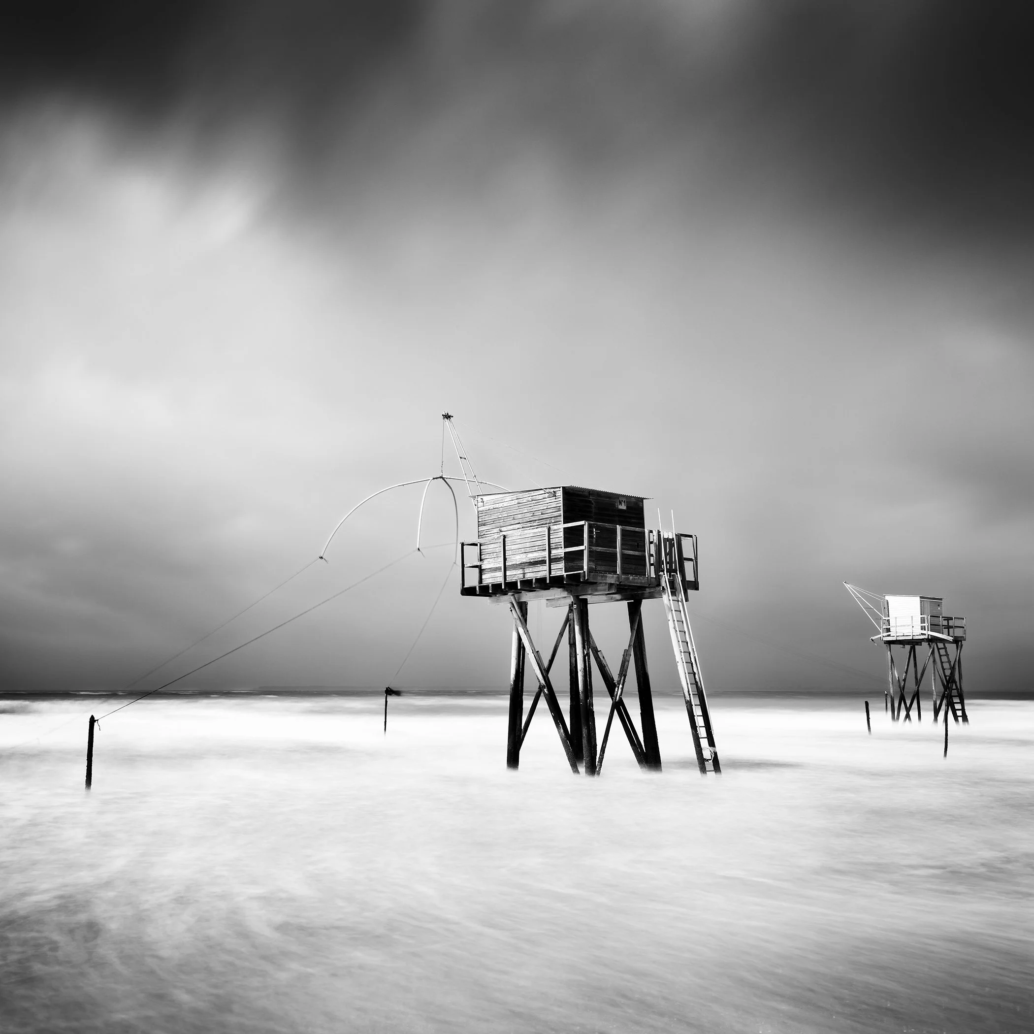 Black-and-white long-exposure photograph of a fishing hut on stilts on the French coast by Gerald Berghammer.