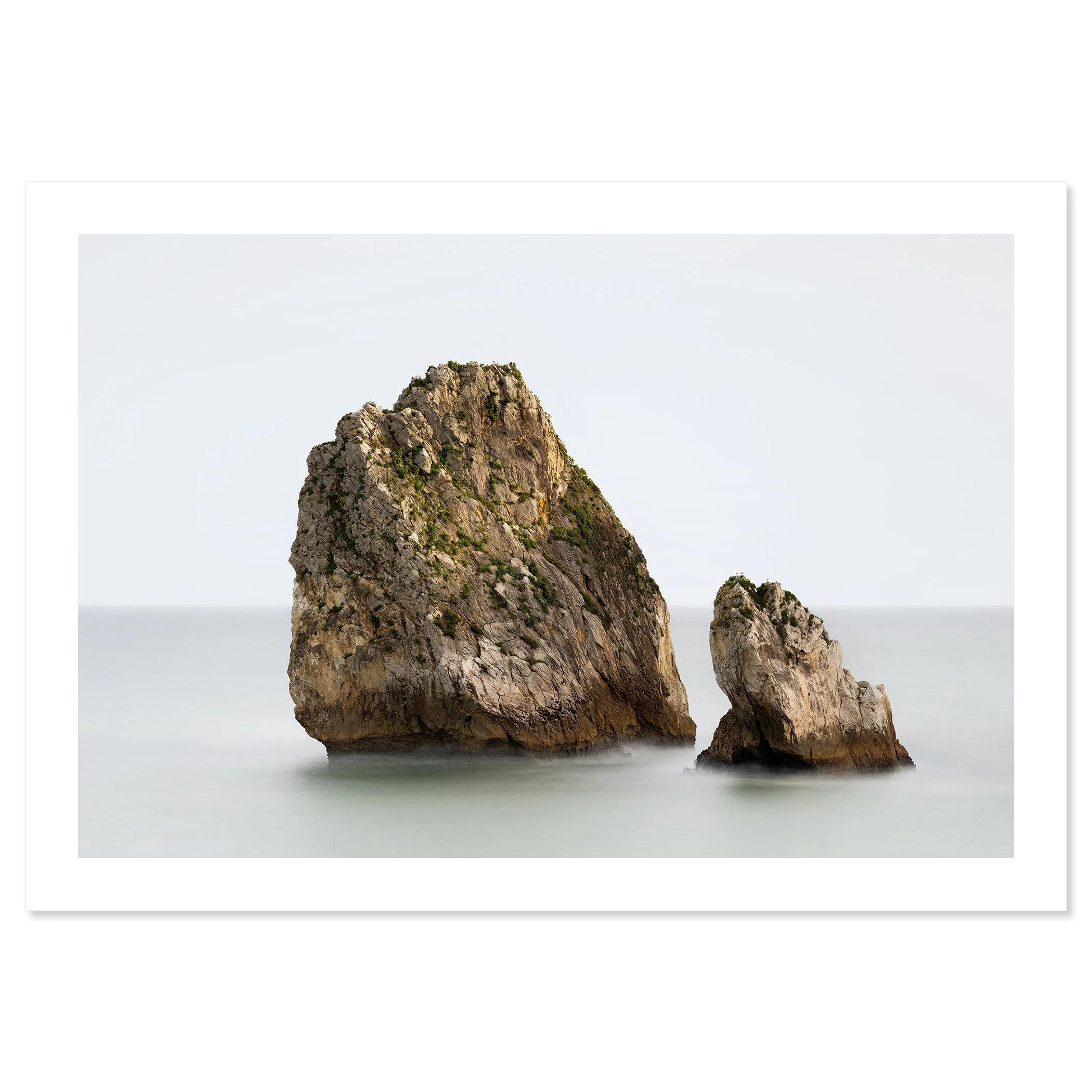 Gerald Berghammer - Color long exposure seascape Photography. Two large rocks protruding from the calm Atlantic Ocean, with a plain, hazy sky. Print only