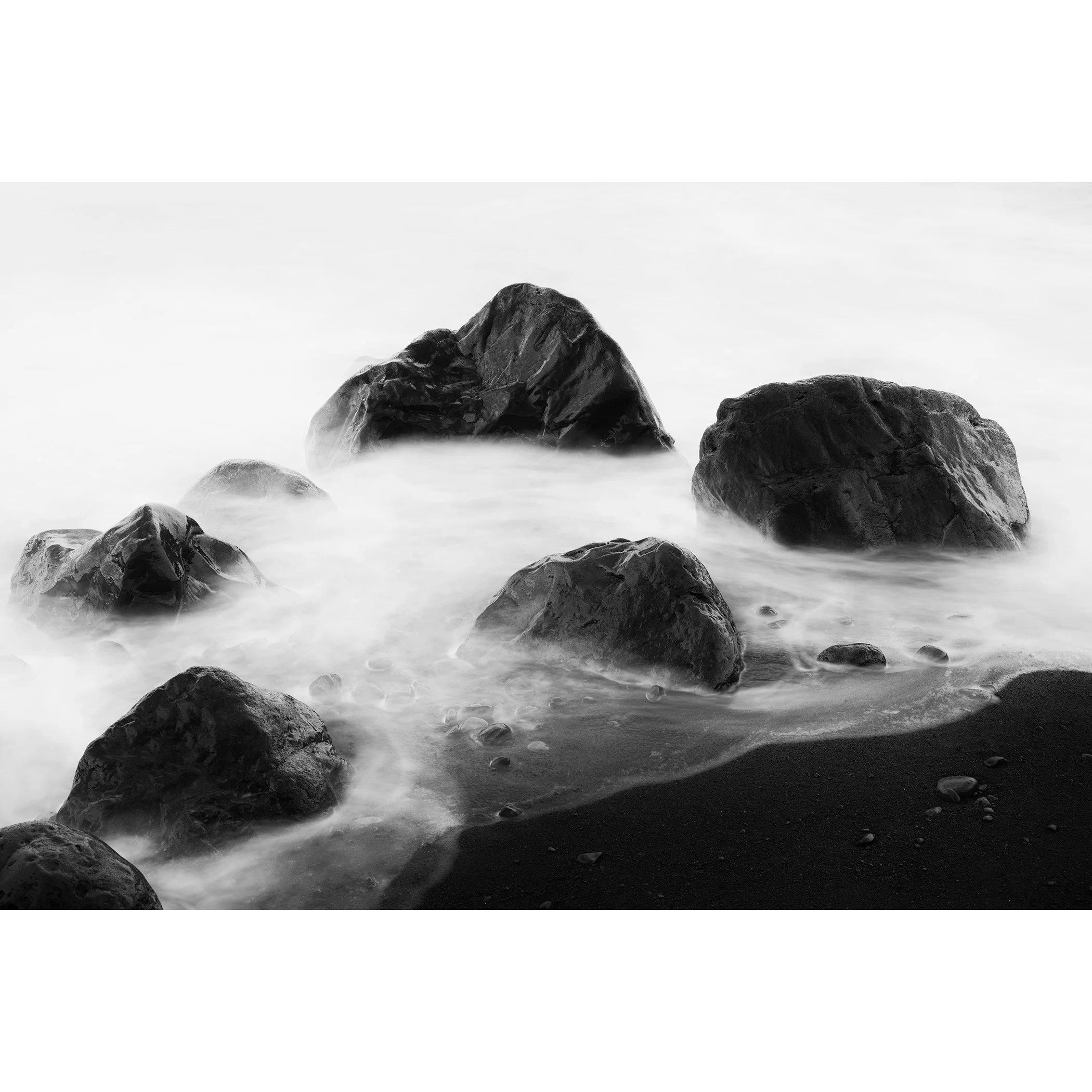 Black-and-white long-exposure seascape of volcanic rocks and misty water, La Gomera, Spain, by Gerald Berghammer.